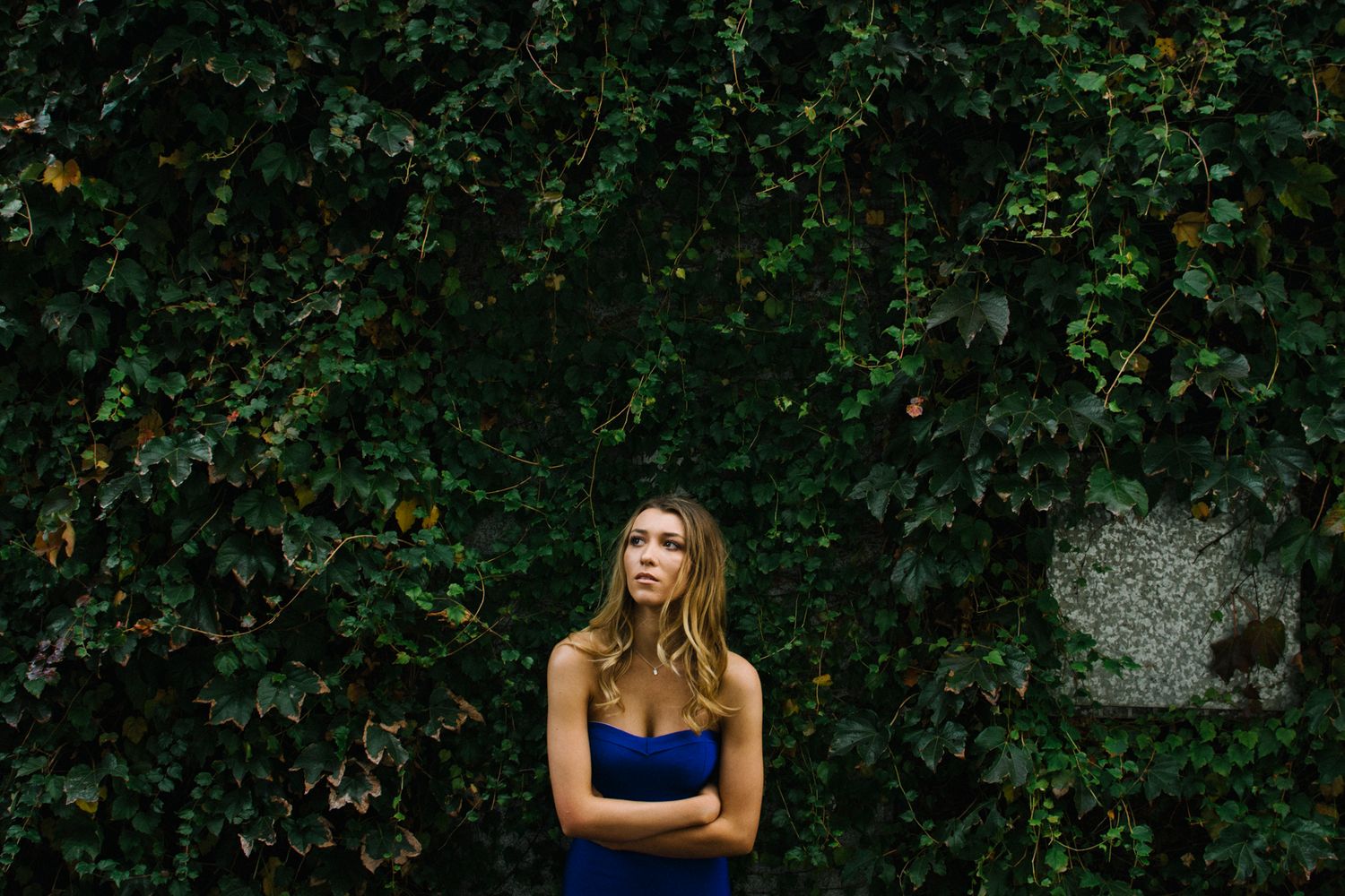 Model hugging herself surrounded by greenery during outdoor photo shoot in Newtown - Zara King Photography, Sydney Australia