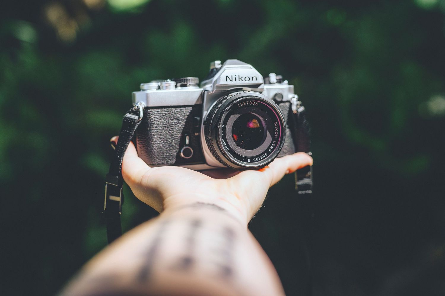 Zara's arm holding a Nikon film camera - Zara King Photography, Lens + Latte Collective