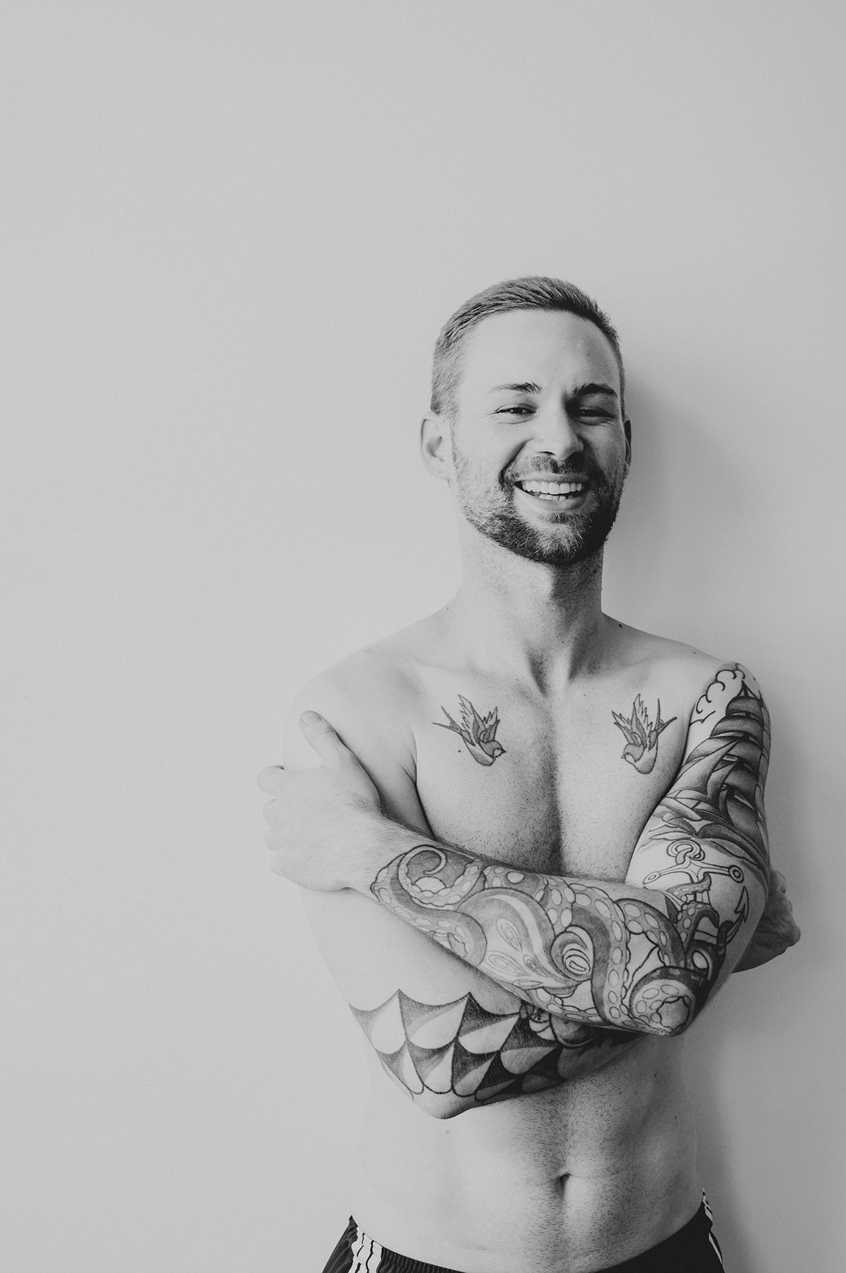 Man laughing with arms crossed during naturally lit indoor headshot session in Wellington, NZ - Zara King Photography