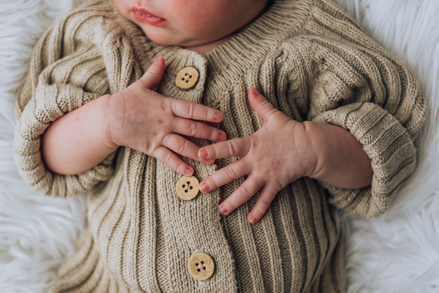 Newborn baby asleep on the bed with her hands on her chest - Zara King Photography, Sydney Australia