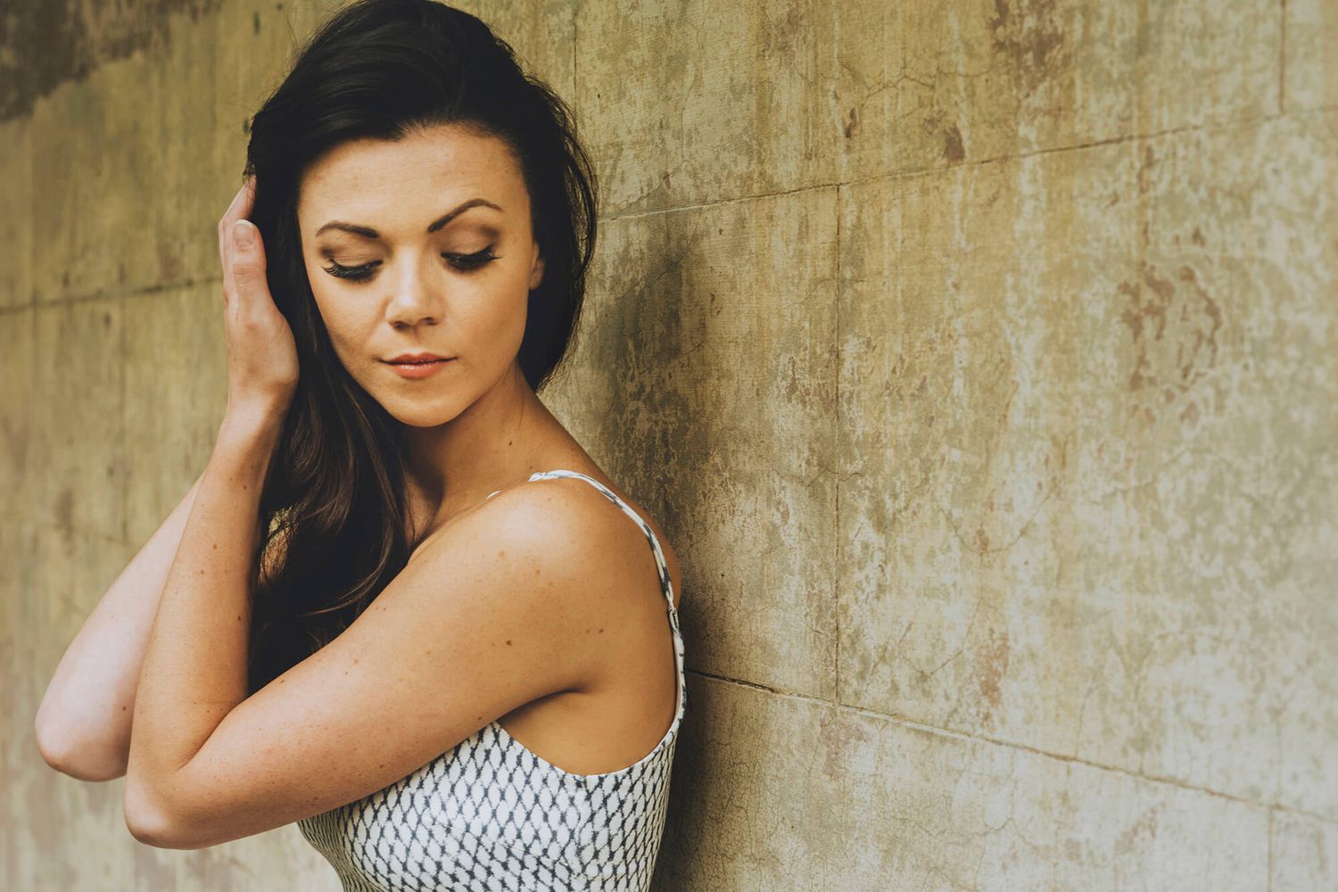 Girl holding hair back and looking down during professional headshot session outdoors in Newtown - Zara King Photography, Sydney Australia