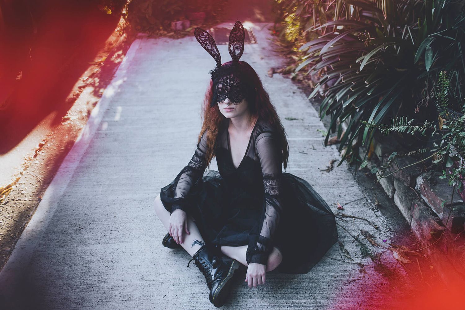 Girl sitting on footpath wearing black dress and black lace mask with bunny ears in Newtown - Zara King Photography, Sydney Australia