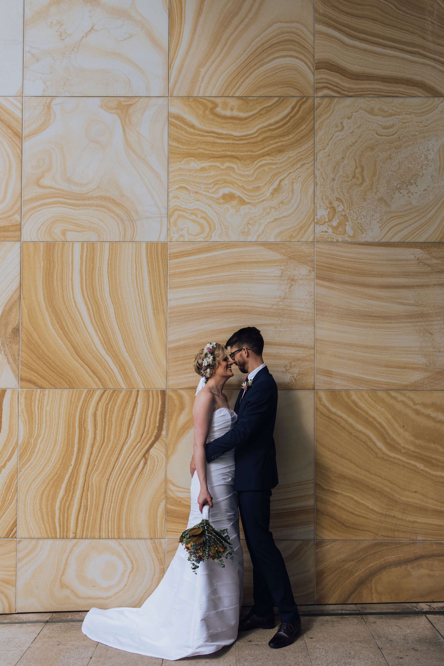 Bride and groom kissing in front of sandstone wall - Zara King Photography, Sydney Australia
