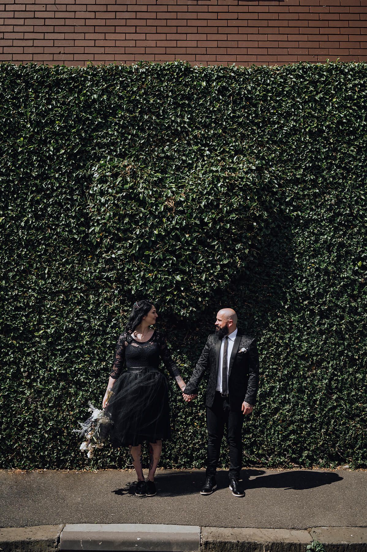 Alternative bride and groom holding hands looking at each other in Fitzroy, Melbourne - Zara King Photography, Australia