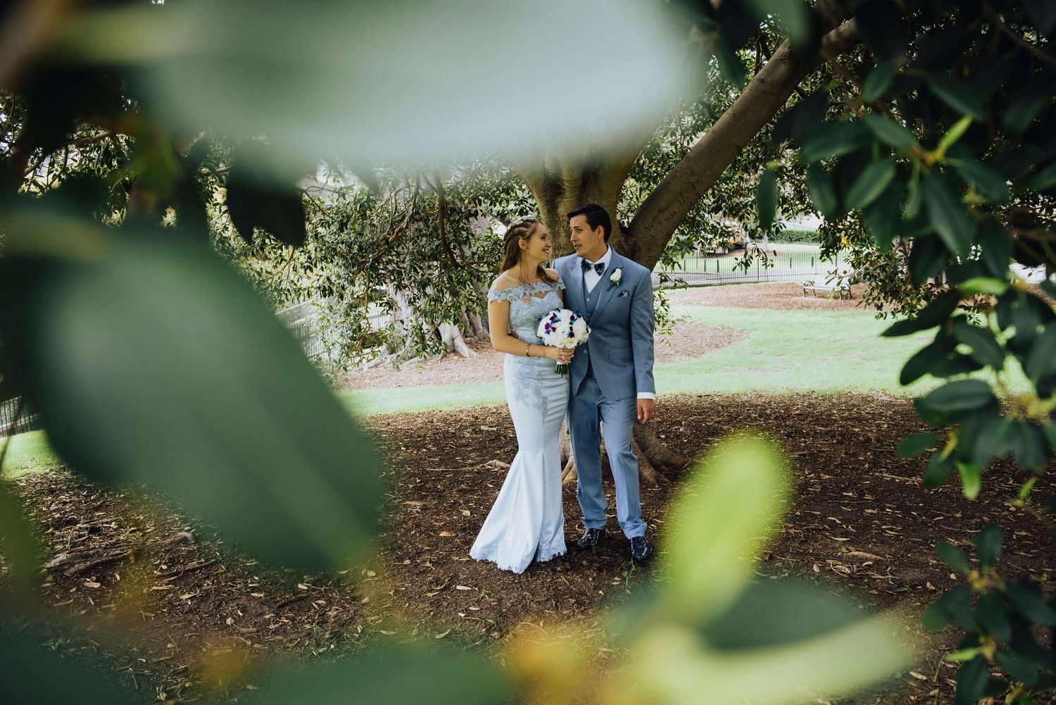 Bride and groom laughing under tree at Observatory Hill Park - Zara King Photography, Sydney Australia