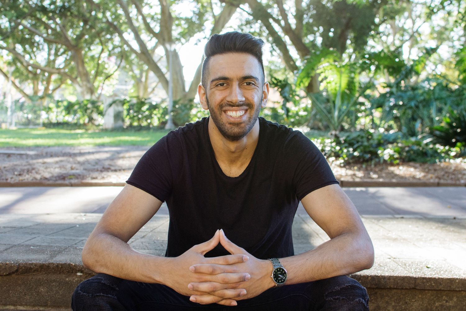 Man sitting with hands interlocked during outdoor creative headshot session in Hyde Park - Zara King Photography, Sydney Australia