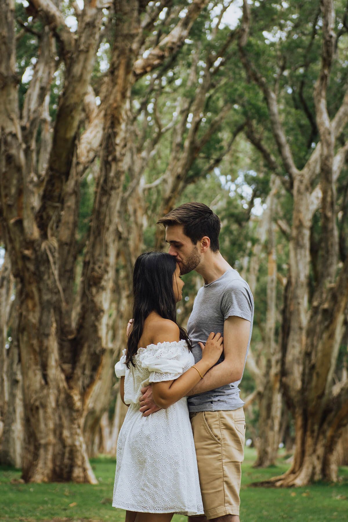 Man kissing female fiancé's forehead in Centennial Park - Zara King Photography, Sydney Australia