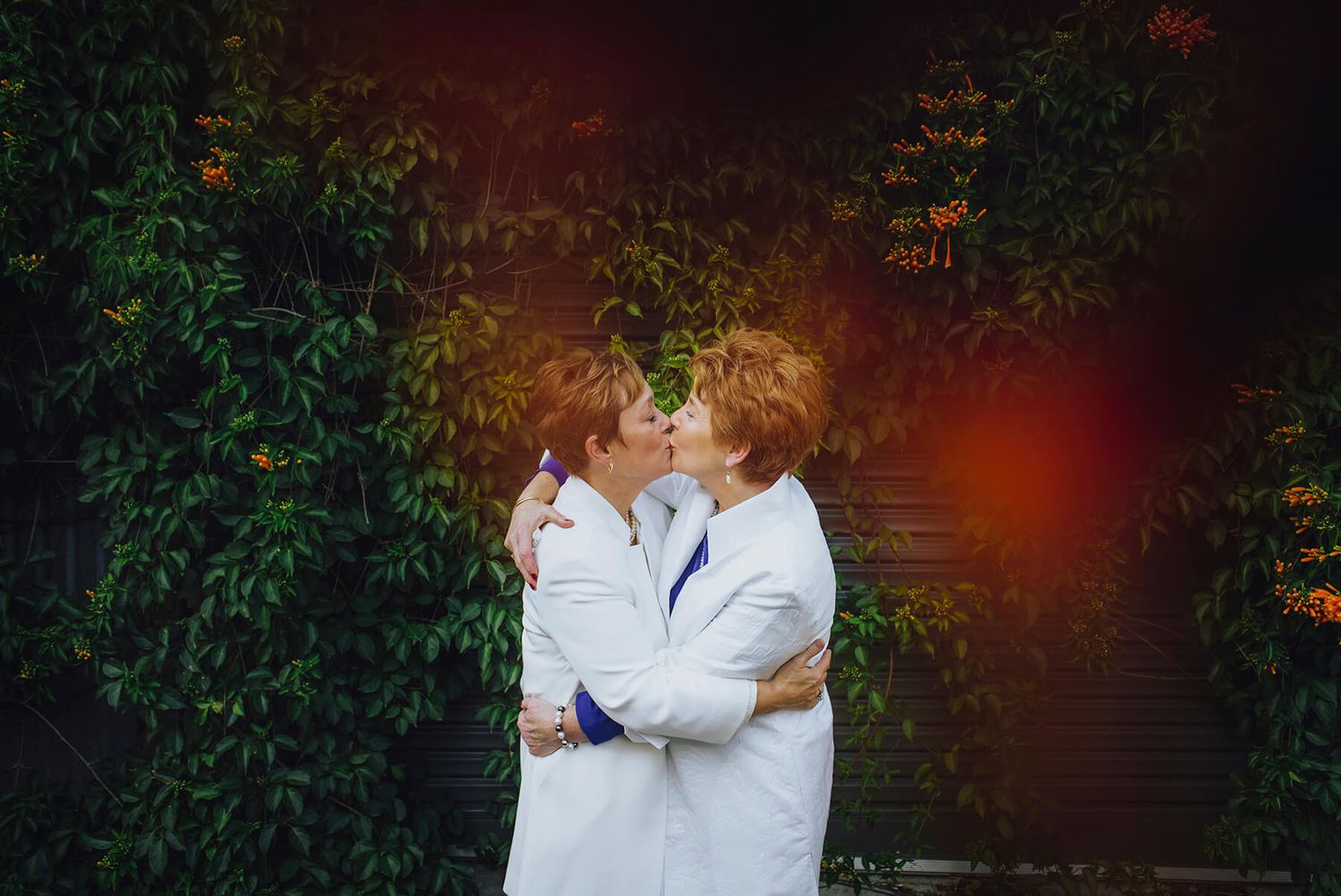 Two brides hugging and kissing in the street in Newtown - Zara King Photography, Sydney Australia