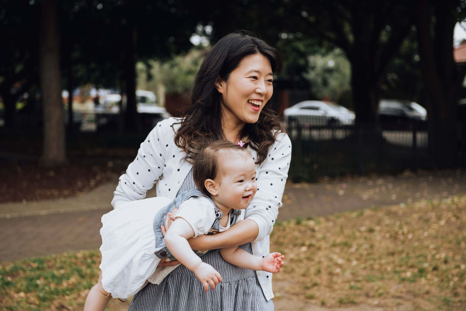 Mum pretending baby daughter is an airplane during outdoor family session in Rosebery - Zara King Photography, Sydney Australia