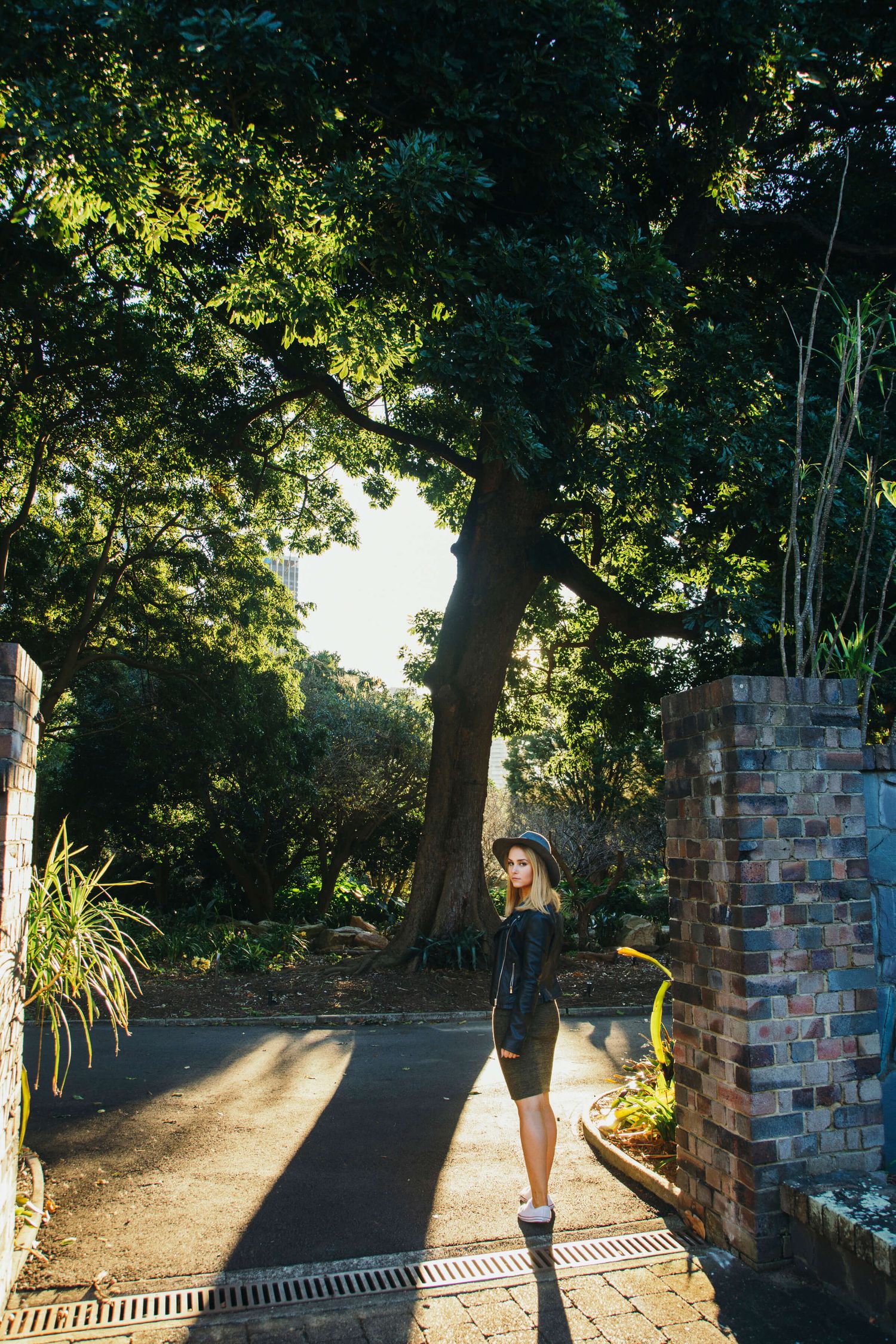 Girl walking away but looking back at sunset in Botanical Gardens - Zara King Photography, Sydney Australia