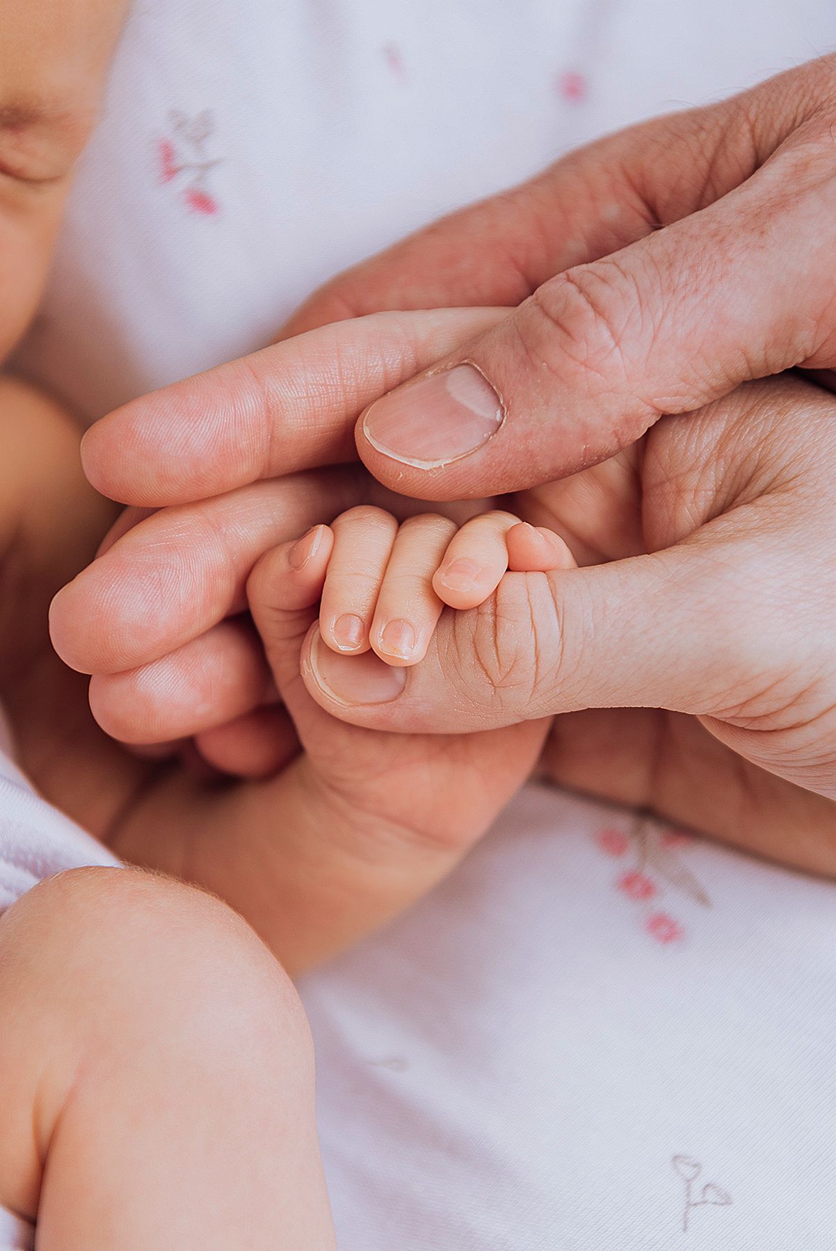 Newborn baby's holding it's mother's thumb, with dad's hand stacked underneath - Zara King Photography, Sydney Australia