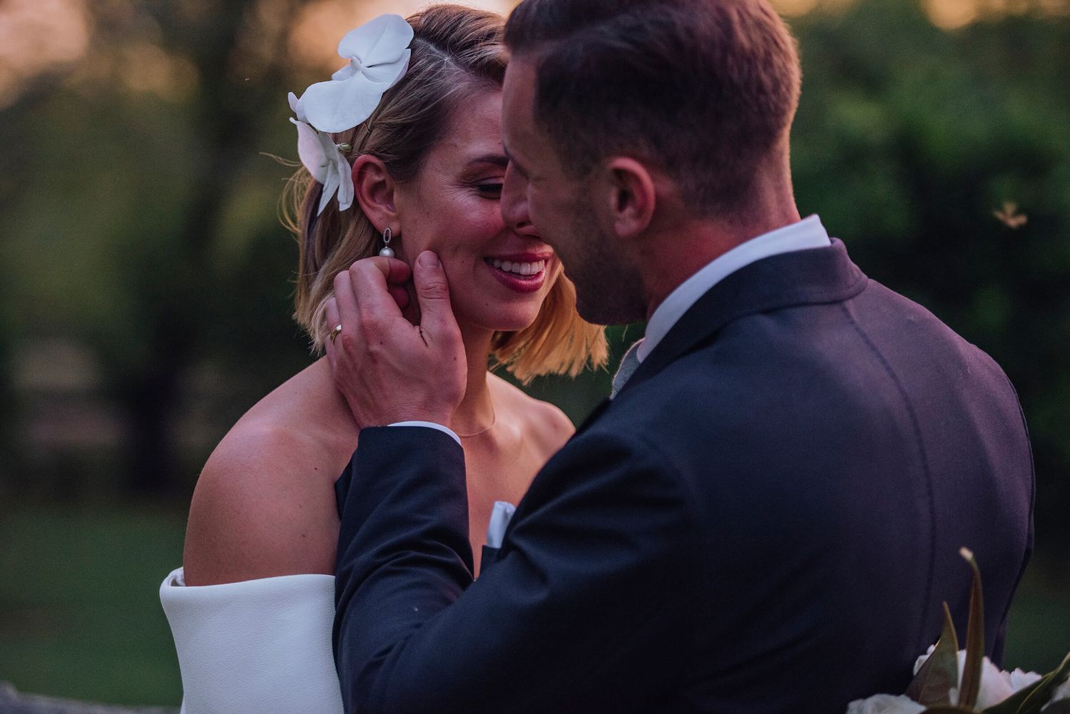 Newly married groom tucks hair behind bride's ear at sunset at Melross Farm in Kangaroo Valley - Zara King Photography, Sydney Australia