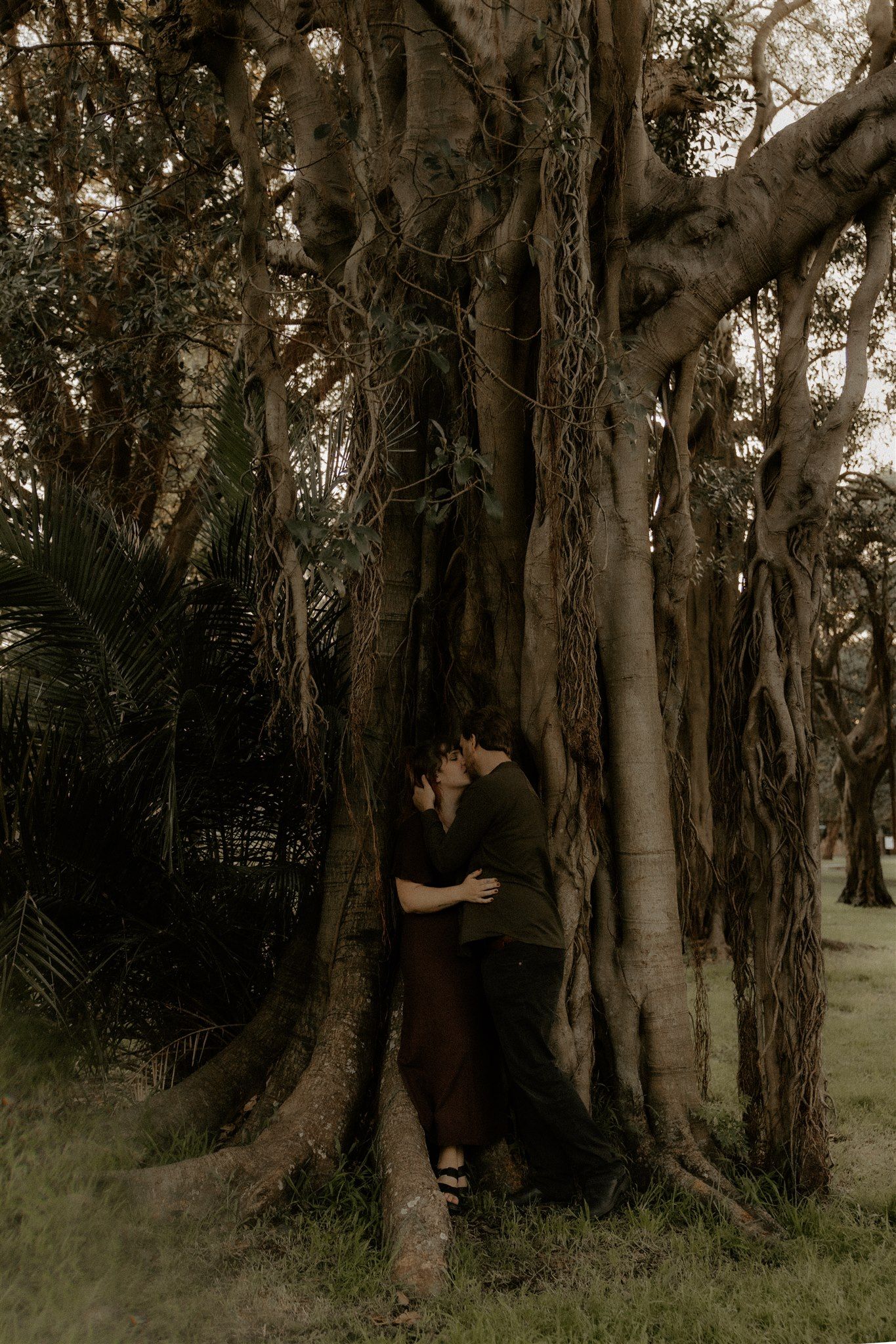 Zara King and fiancé kissing in amongst tree roots