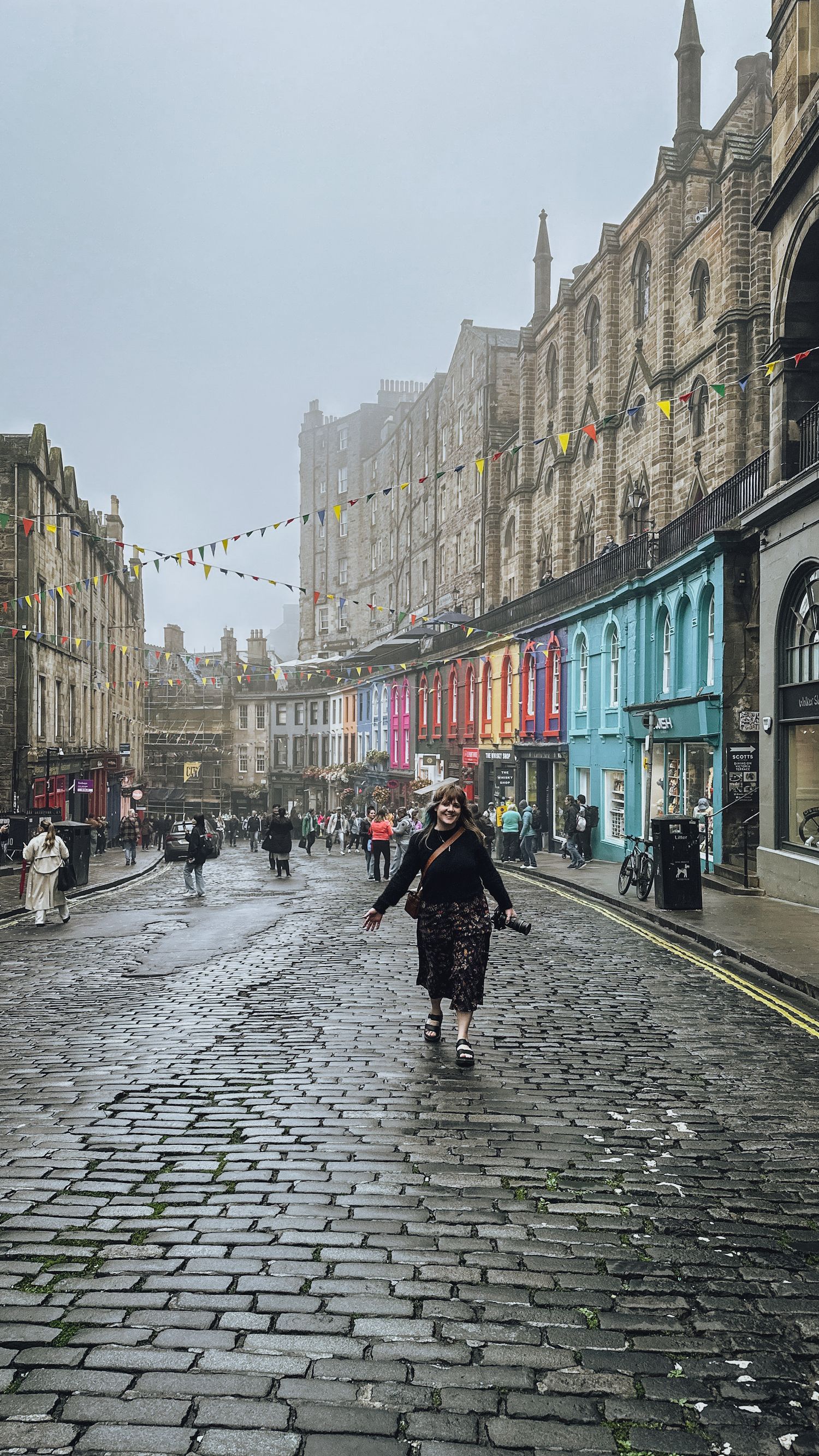 Girl walking down colourful cobblestone street in Edinburgh, Scotland  - Zara King Photography