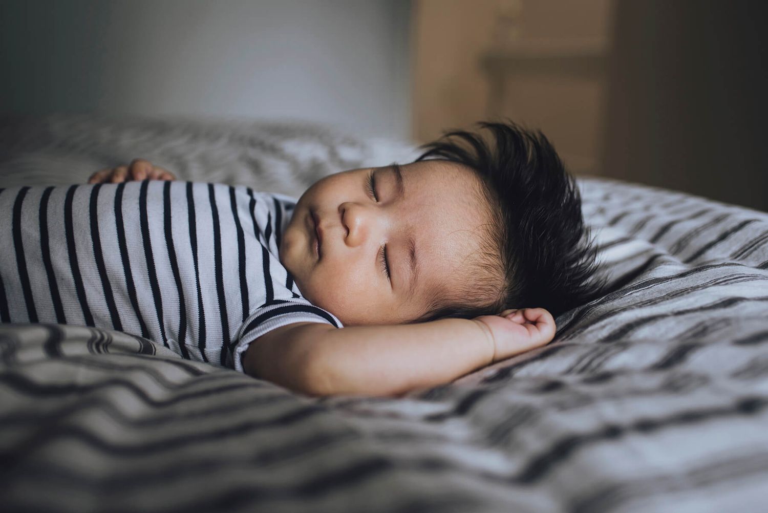 Newborn baby asleep on bed during in-home session - Zara King Photography, Sydney Australia