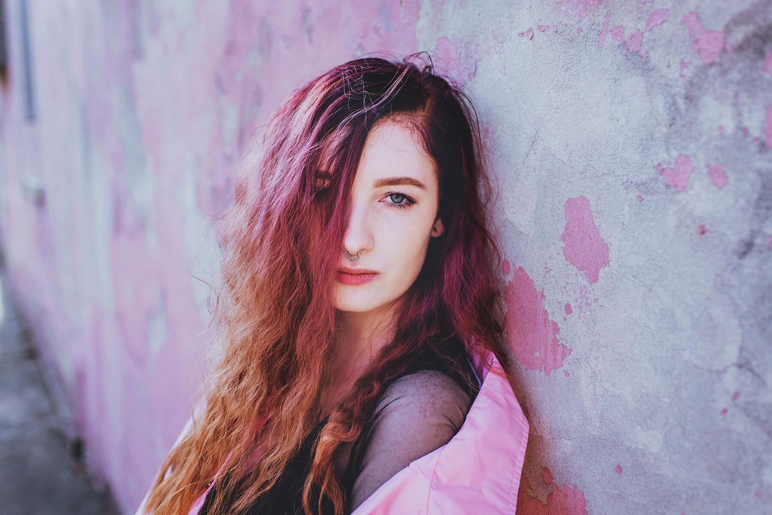 Girl with pink hair and pink jacket sitting in front of pink painted wall in Newtown - Zara King Photography, Sydney Australia
