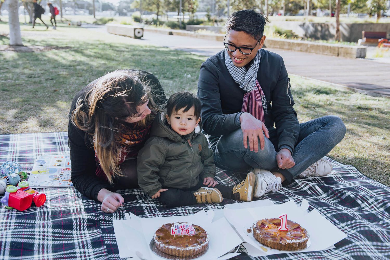 Candid portrait of family interacting with son for his first birthday picnic at Barangaroo - Zara King Photography, Sydney Australia