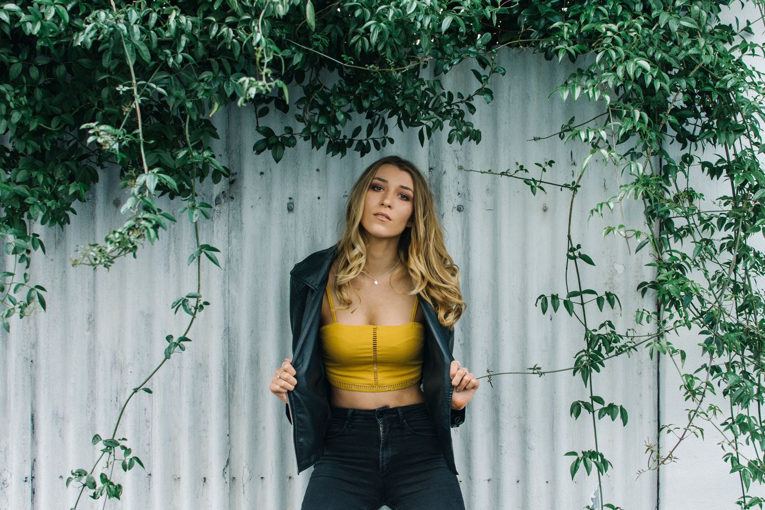 Model holding out edges of leather jacket during outdoor photo shoot in Newtown - Zara King Photography, Sydney Australia