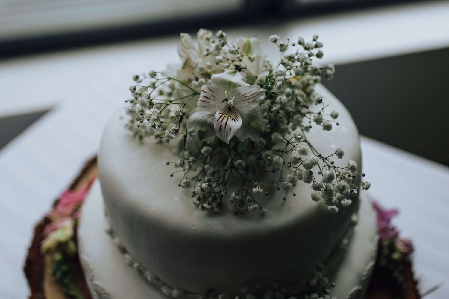 Close up of the top of wedding cake covered in white flowers - Zara King Photography, Sydney Australia