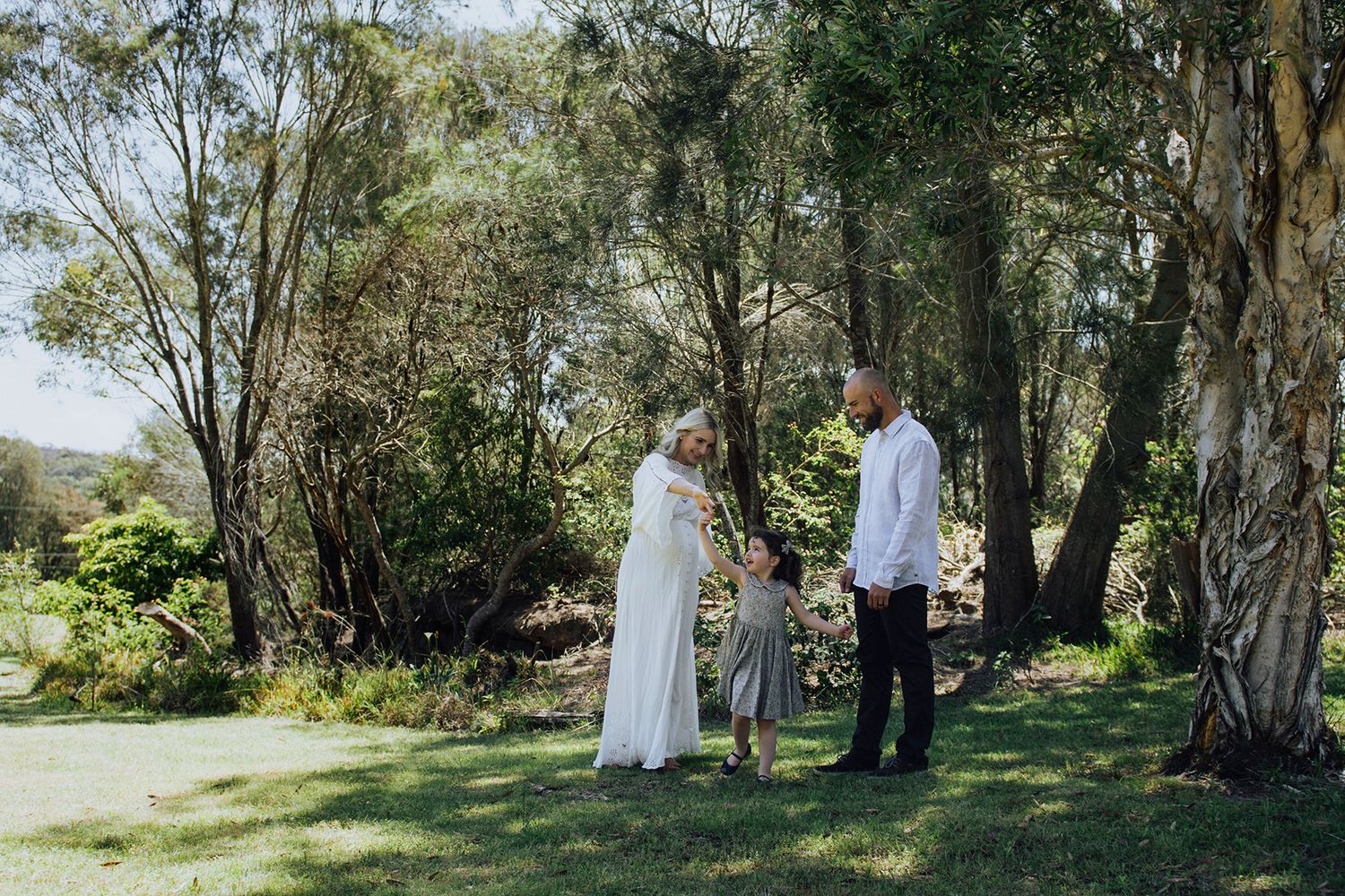 Parents helping daughter dance in backyard during in-home family session - Zara King Photography, Sydney Australia