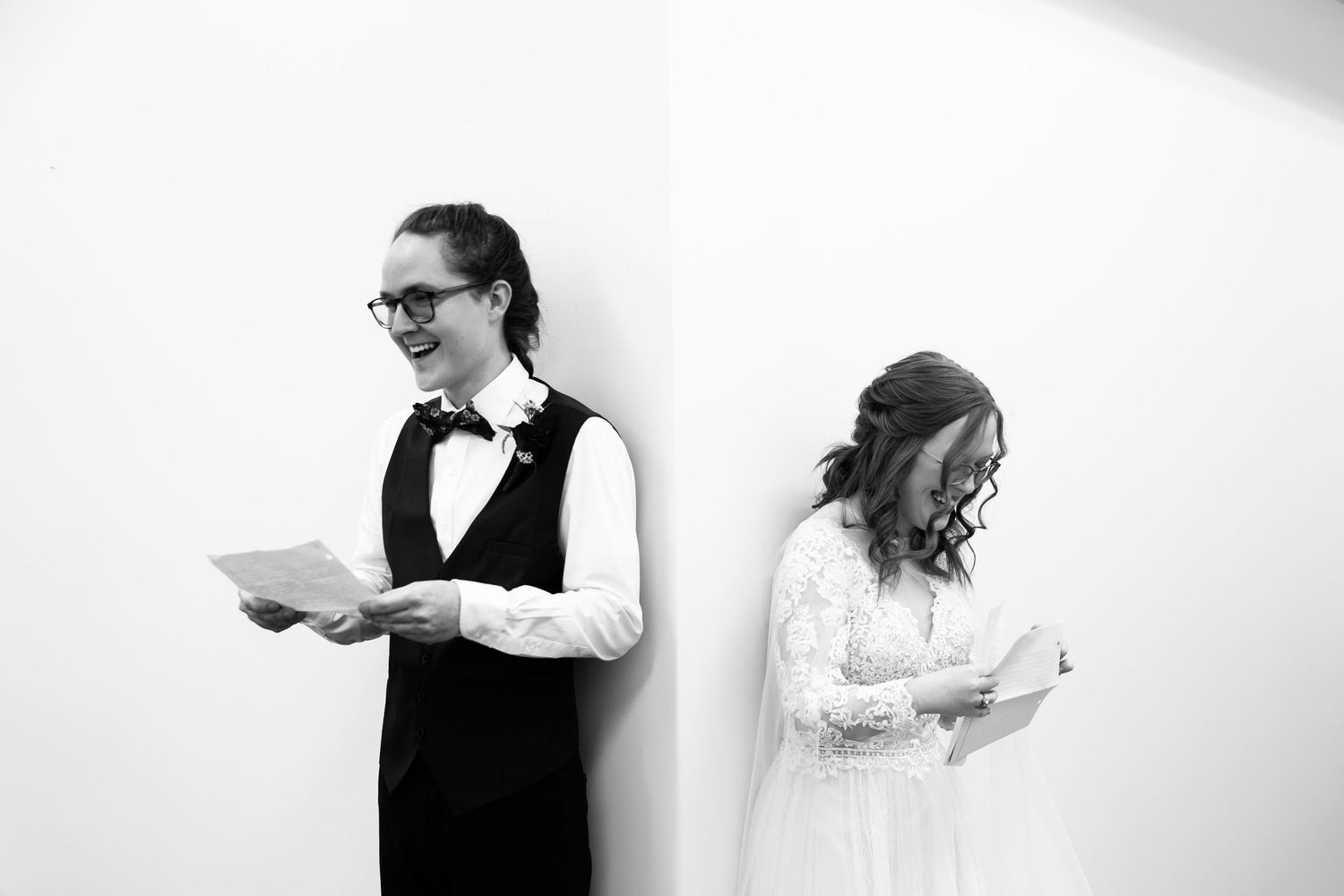 Black and white photo of a couple reading letters back to back.
