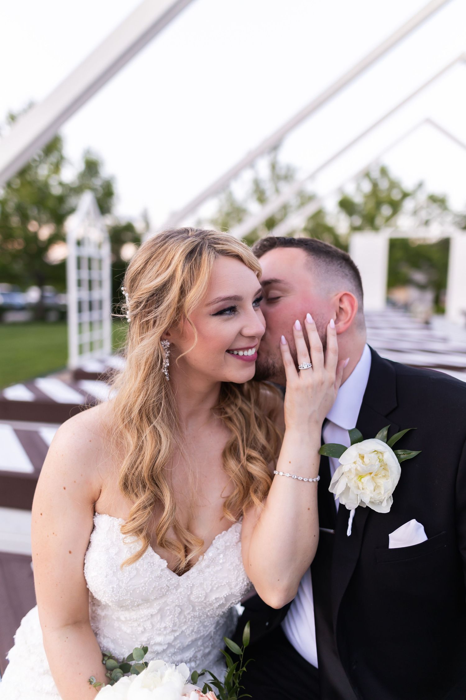 Intimate wedding moment captured between newlyweds during outdoor reception.