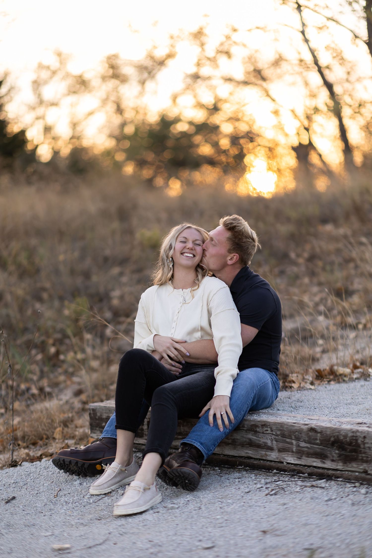 Couple sharing an intimate moment on wooden steps during sunset.