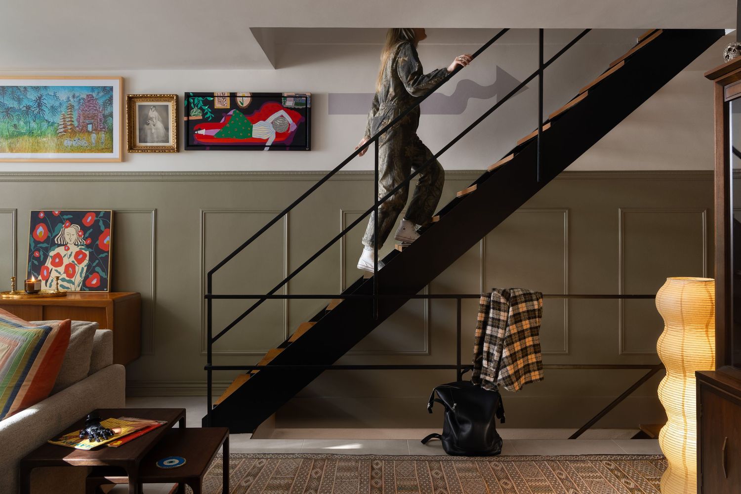 Modern industrial loft interior in Lafayette Park, Detroit, designed by Leslie Olech, featuring a black metal staircase, wood floors, and ec