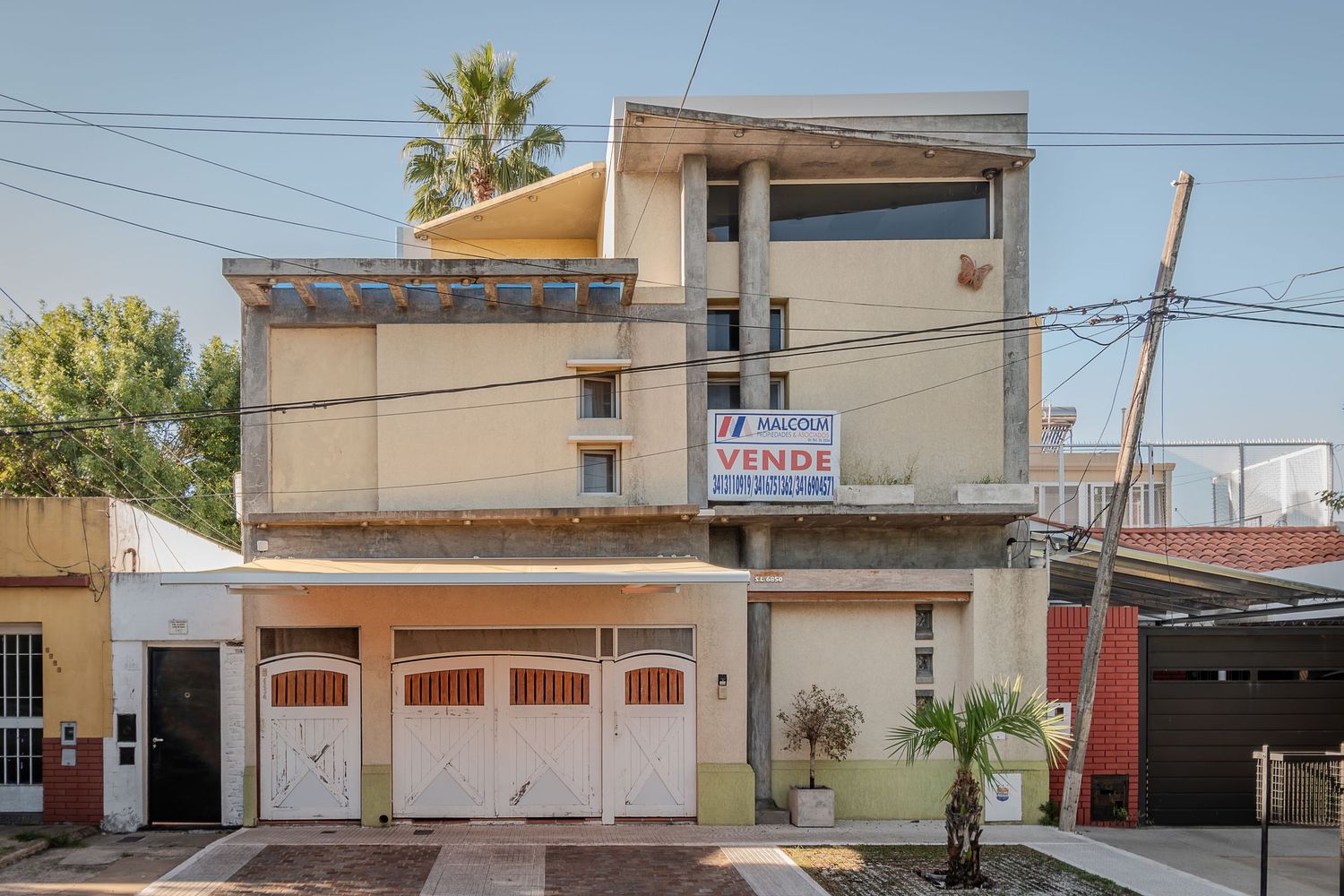 Fotografía de fachada para inmobiliaria de casa de dos plantas con cochera.
