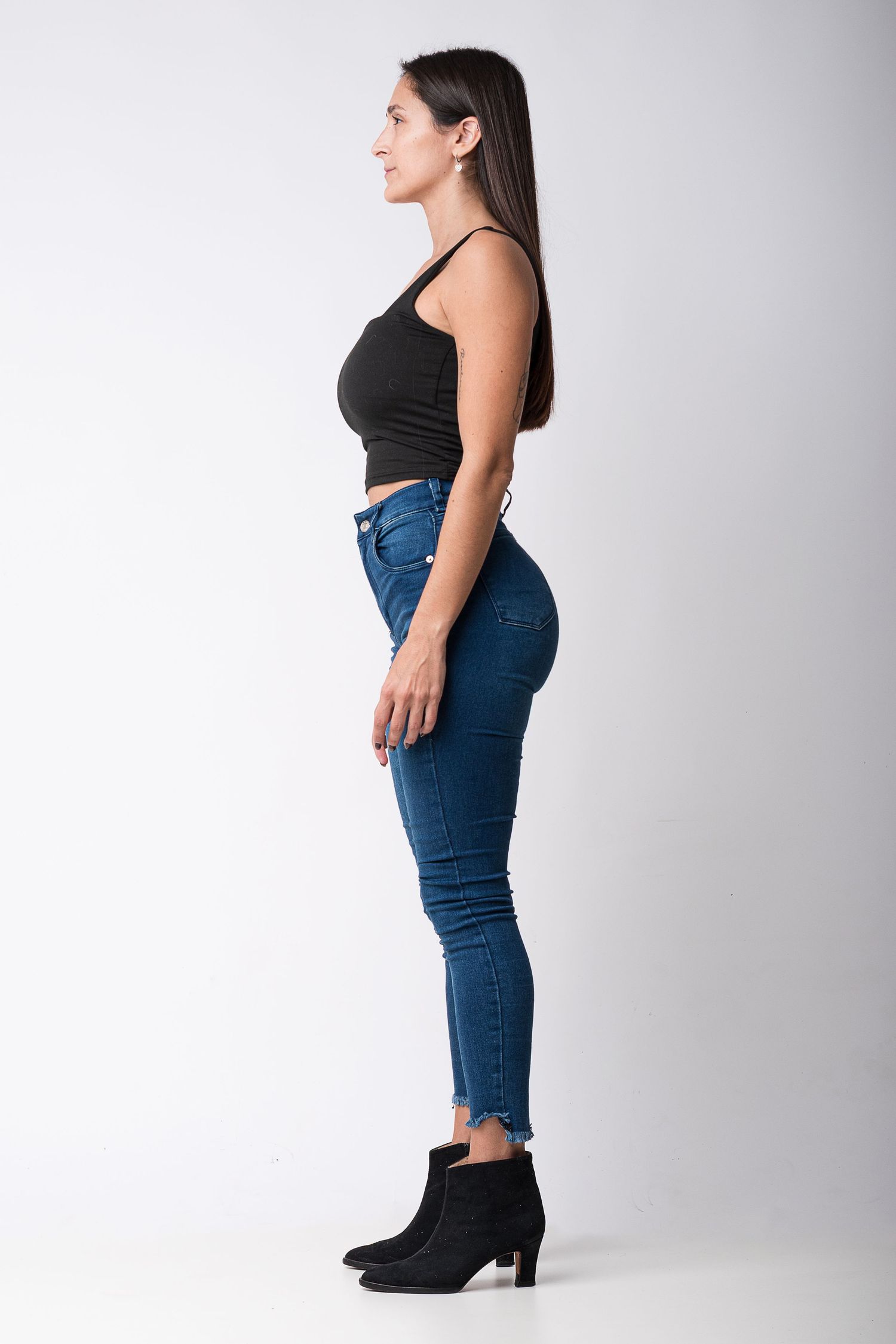 Digital de perfil para modelo con toma lateral de cuerpo entero sobre fondo neutro.