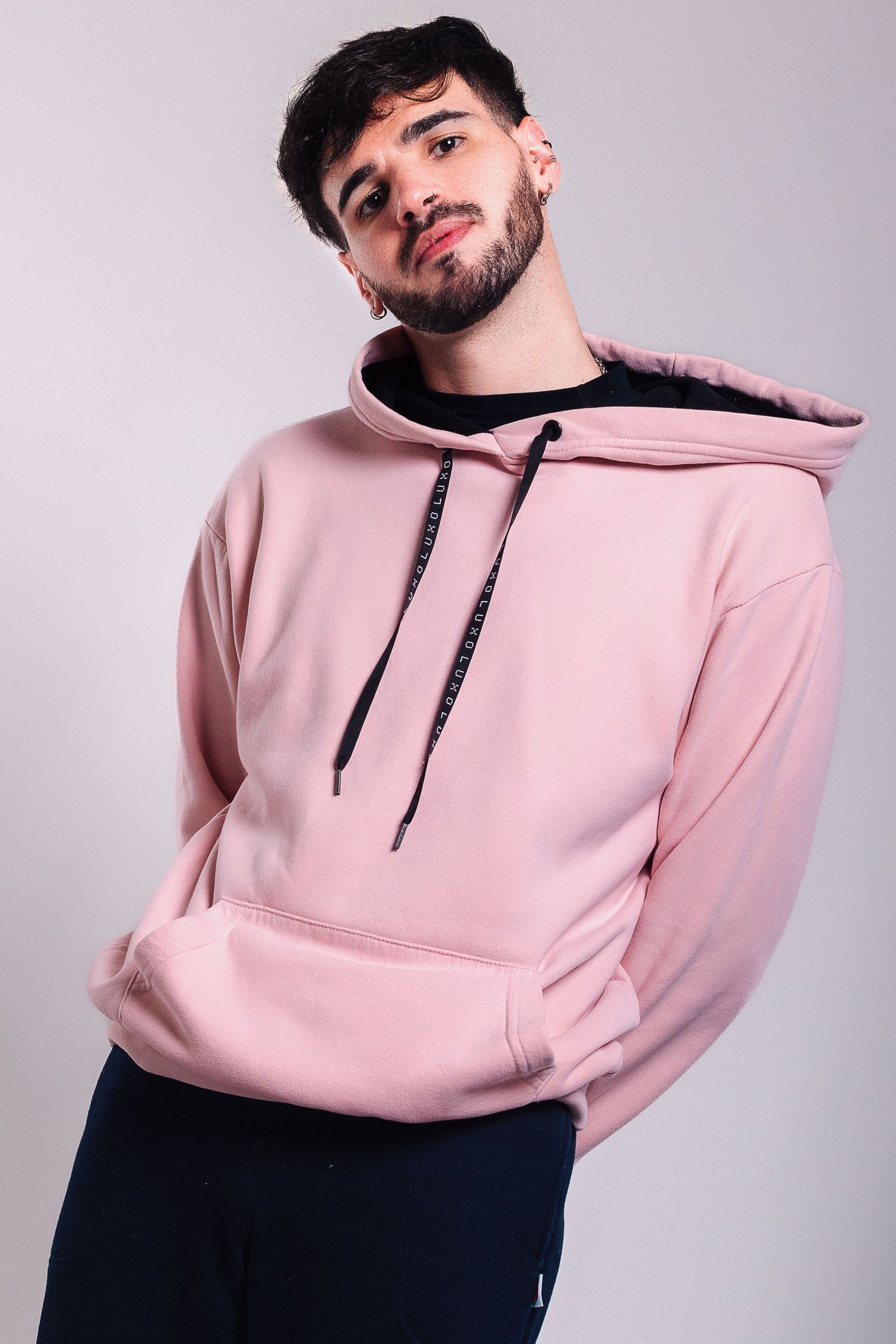 Fotografía e-commerce de indumentaria masculina con buzo rosa en retrato de estudio.