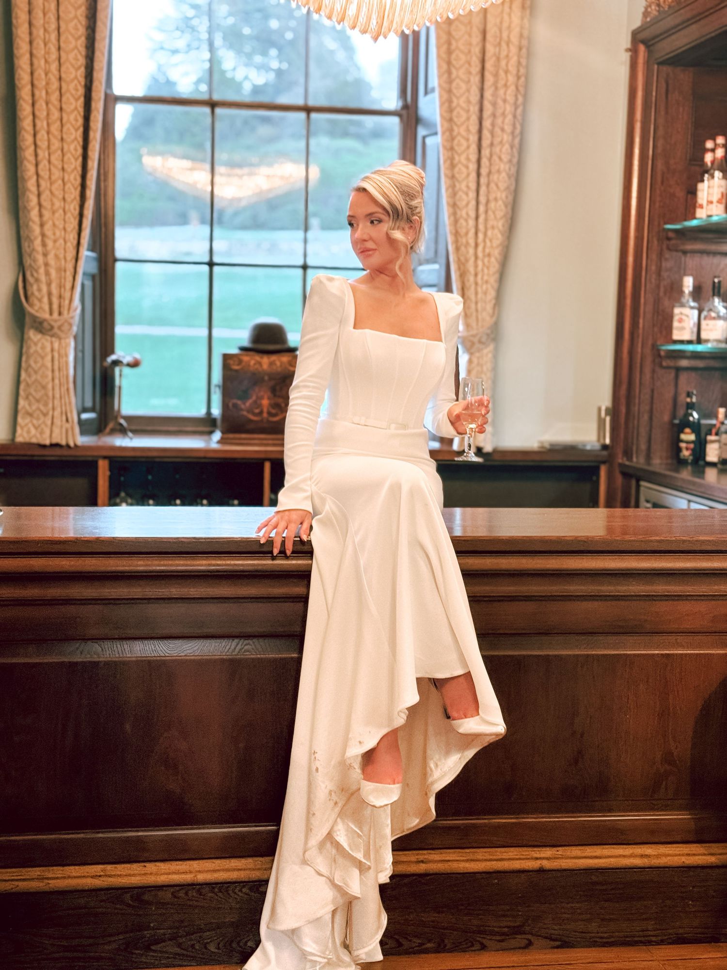 Elegant bridal portraits in a wood-paneled room with large windows.