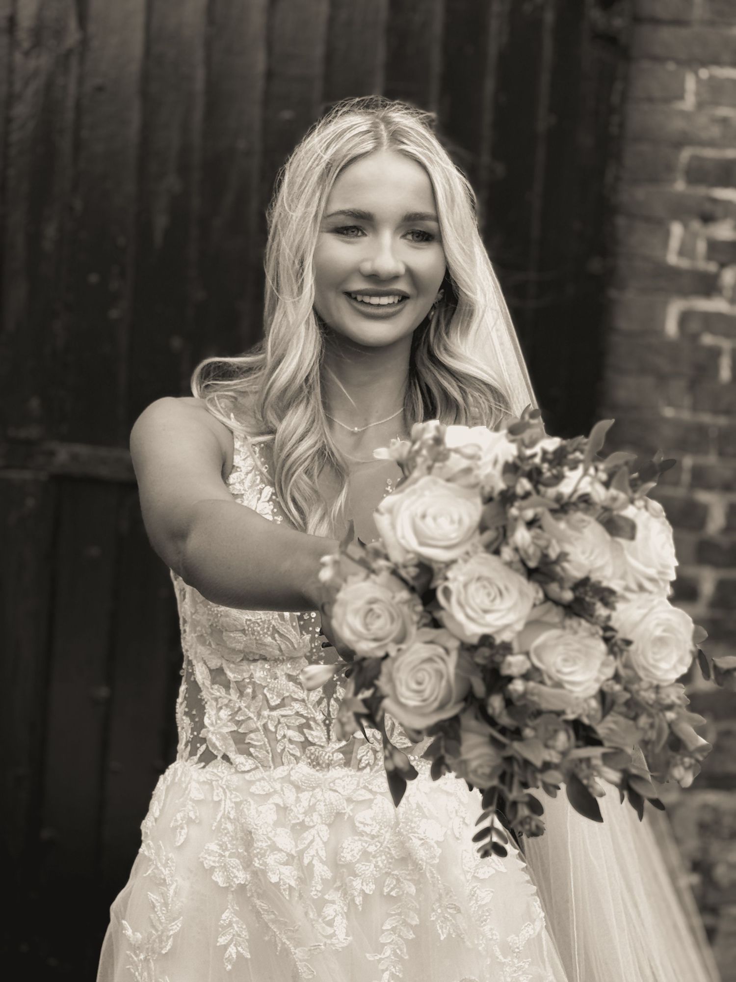 Black and white photos of bride holding elegant rose bouquet against dark background.