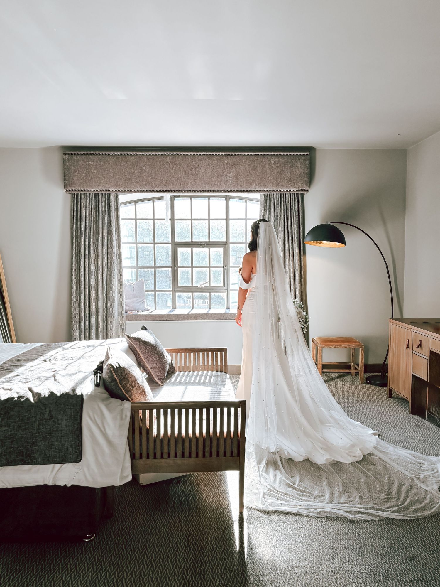 Sequential photos of a white dress floating across a hotel room in artistic motion.