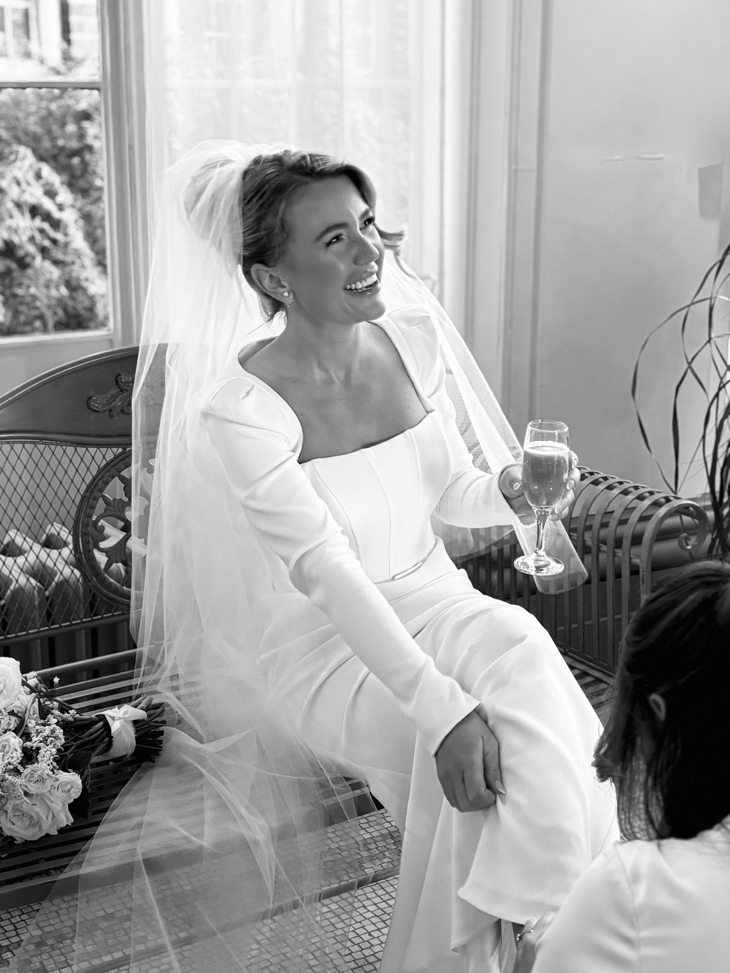 Candid bridal portraits in a bright window-lit room showing joyful moments.