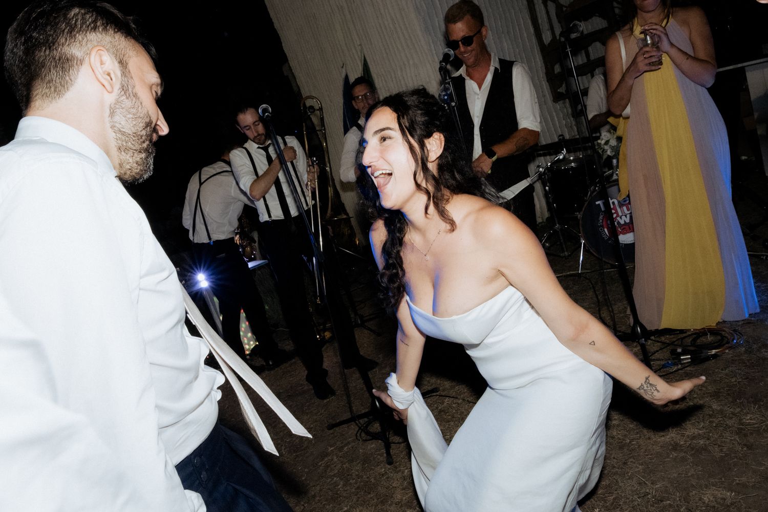 Wedding guests dancing and celebrating on the reception dance floor.