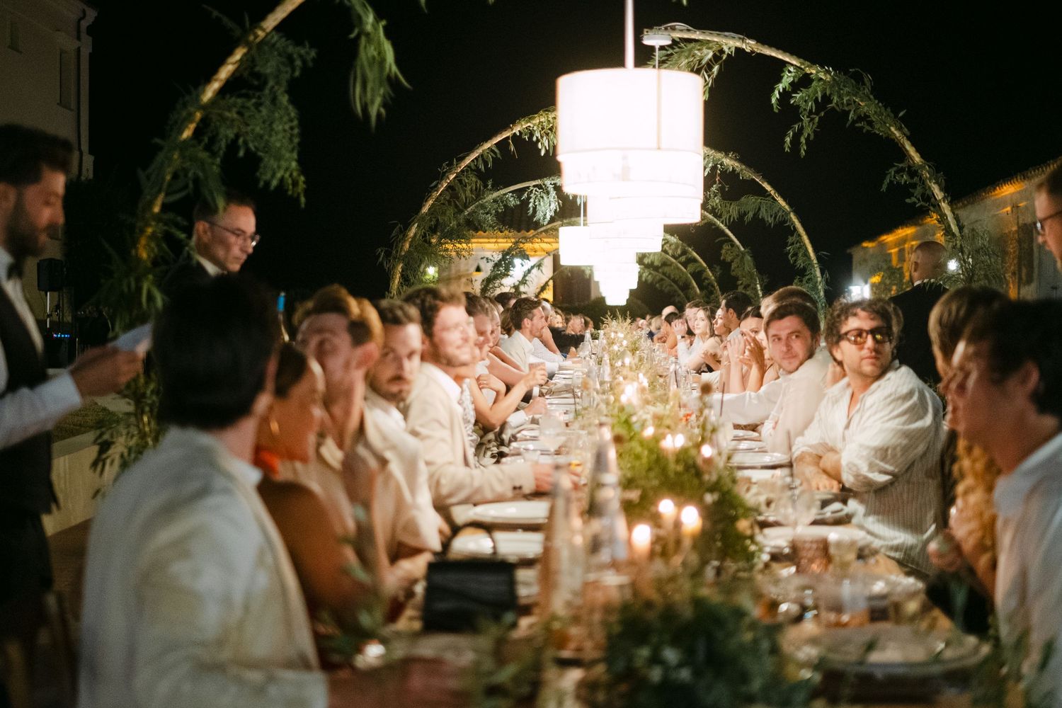 Romantic outdoor wedding reception with string lights creating an intimate ambiance.