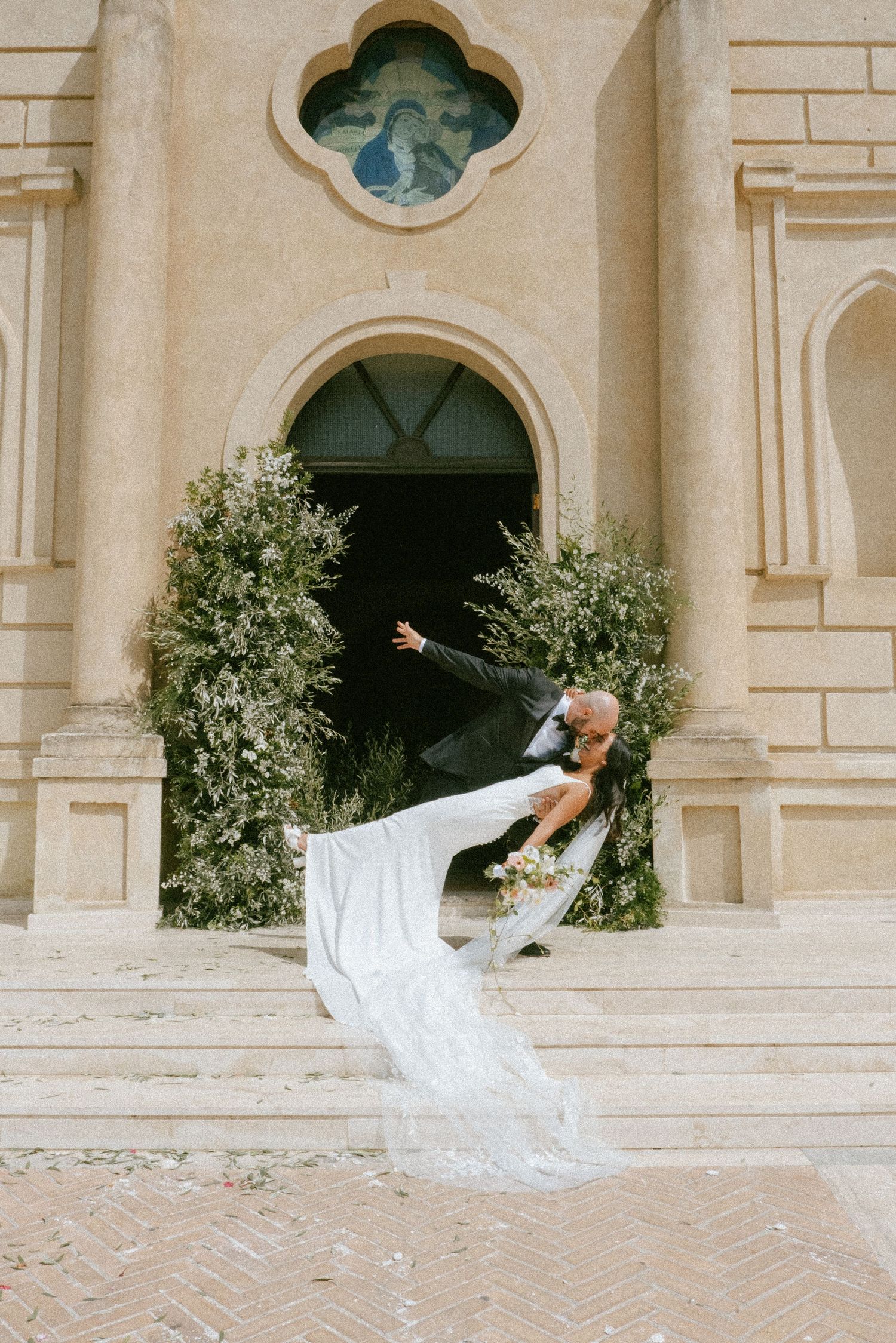 Dynamic dance movements captured in sequence showing flowing white fabric against architectural backdrop.