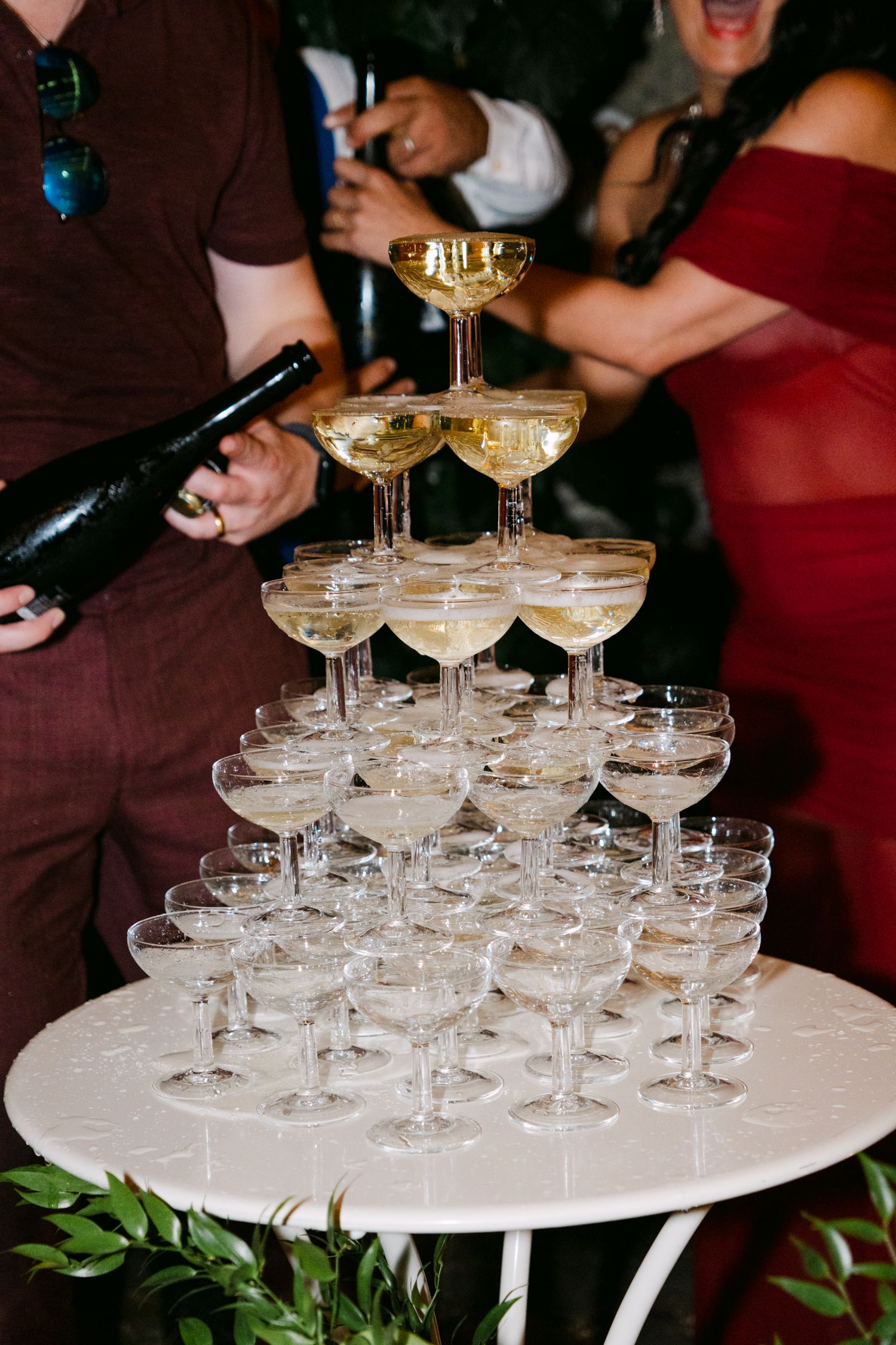 A tower of champagne glasses stacked elegantly on a white serving tray.