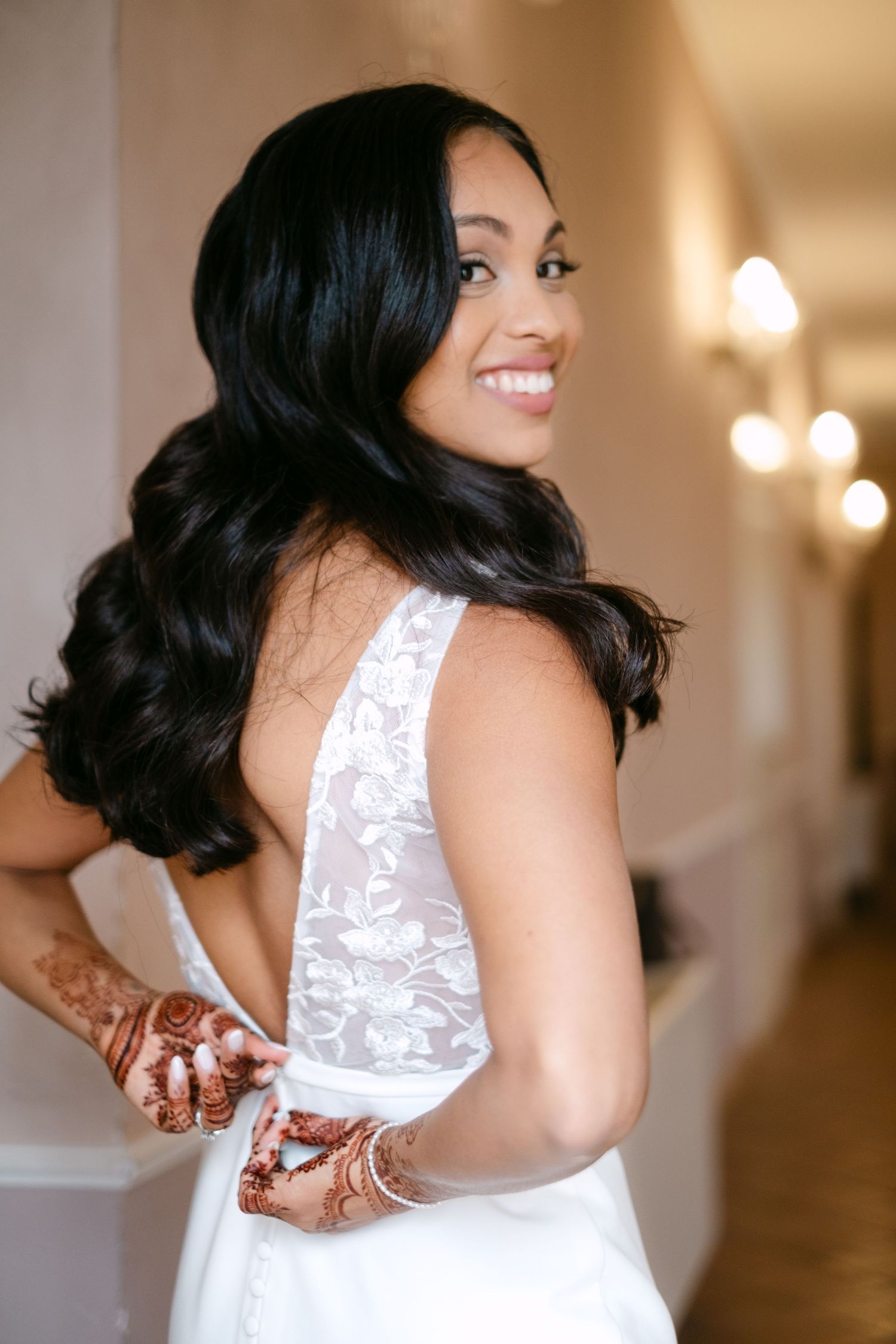 A white lace wedding dress shown from behind with intricate back details.