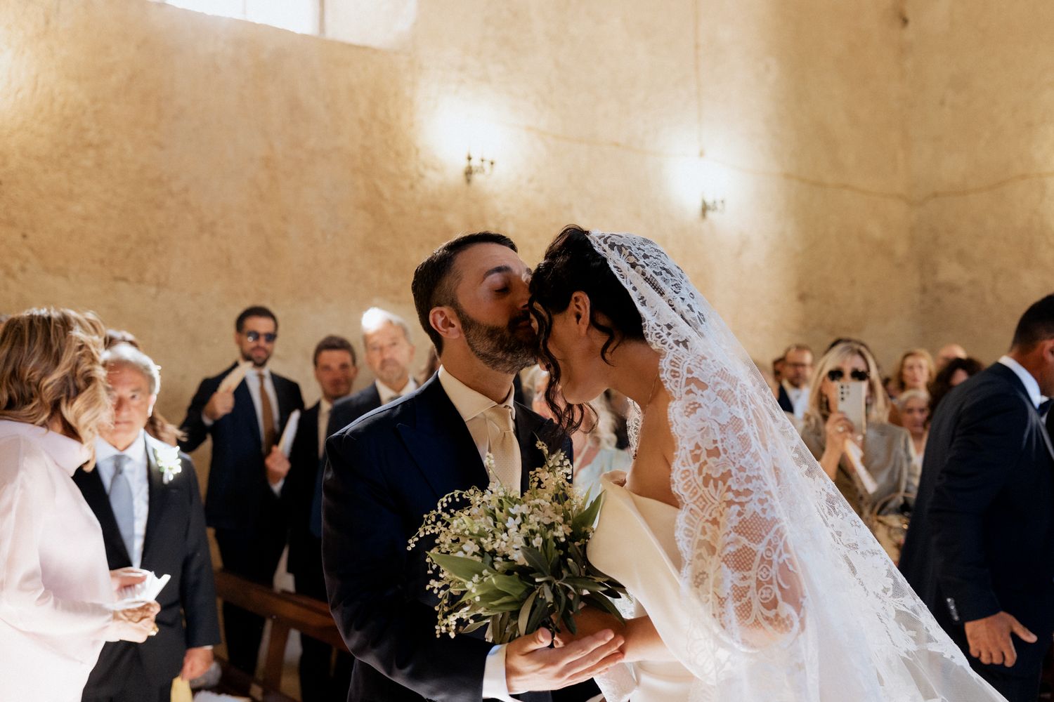 Wedding ceremony in progress inside a rustic stone-walled venue.