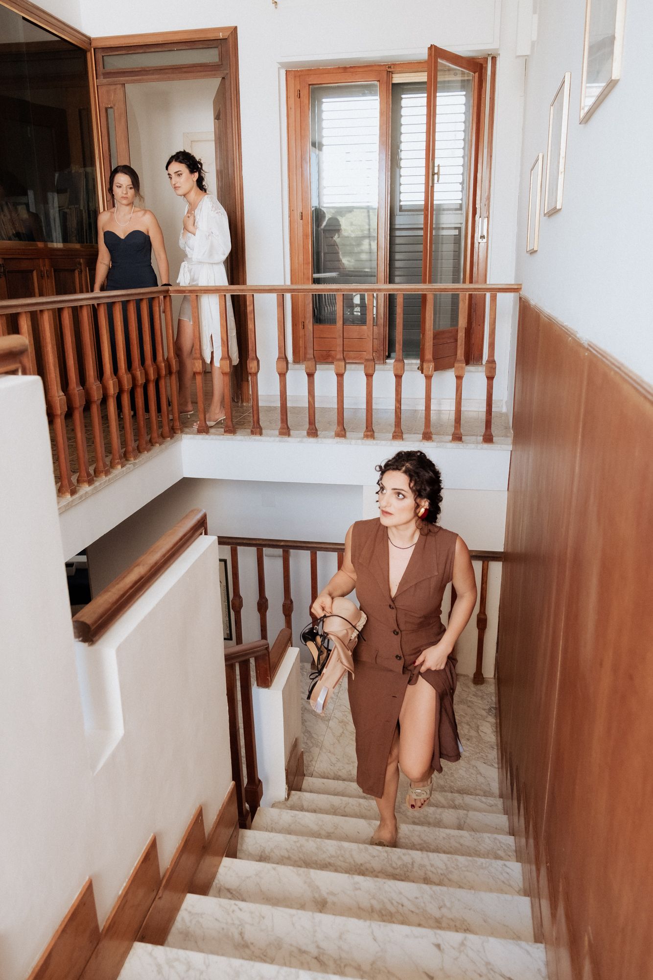 Interior staircase with wooden railings and white walls in a Mediterranean style home.