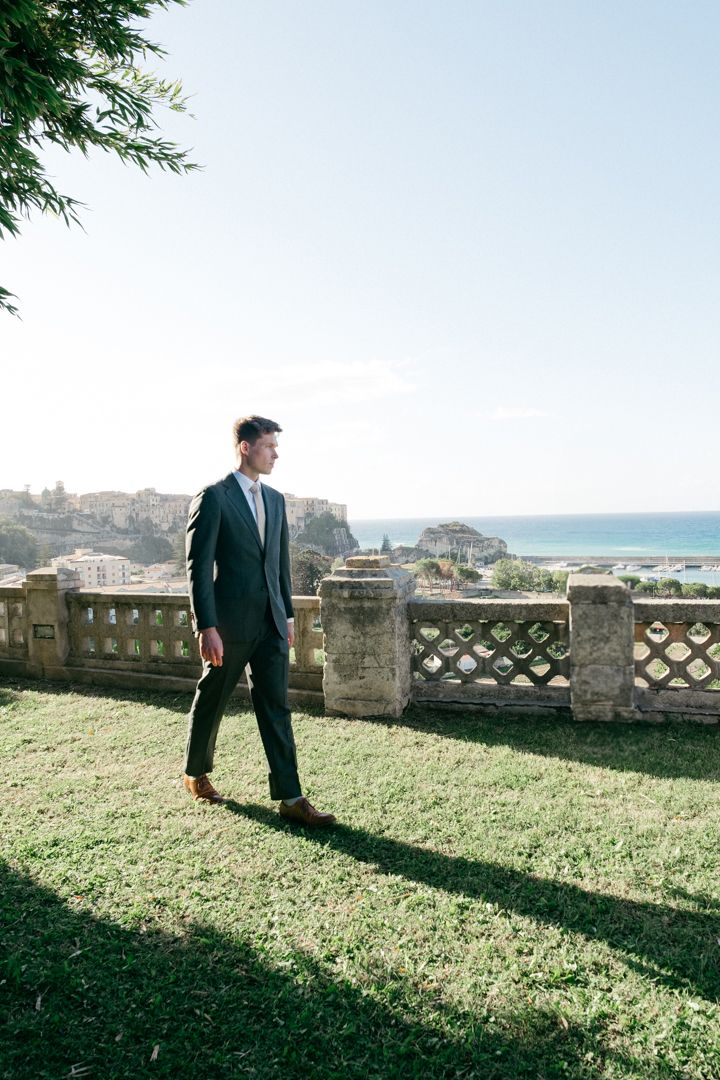 A scenic coastal view from a stone terrace with decorative balustrade overlooking the ocean.