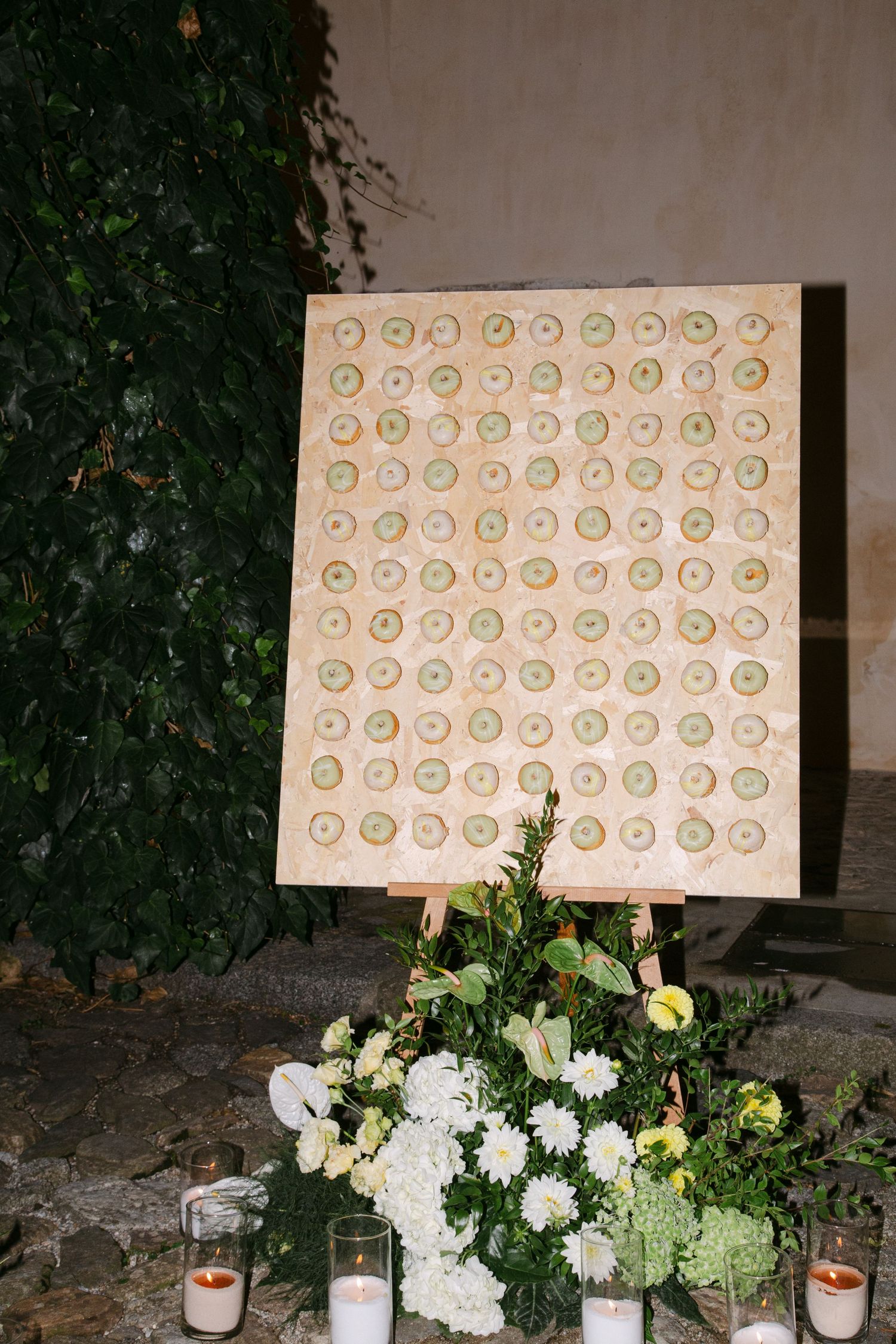 Wedding seating chart display decorated with white and yellow floral arrangements.