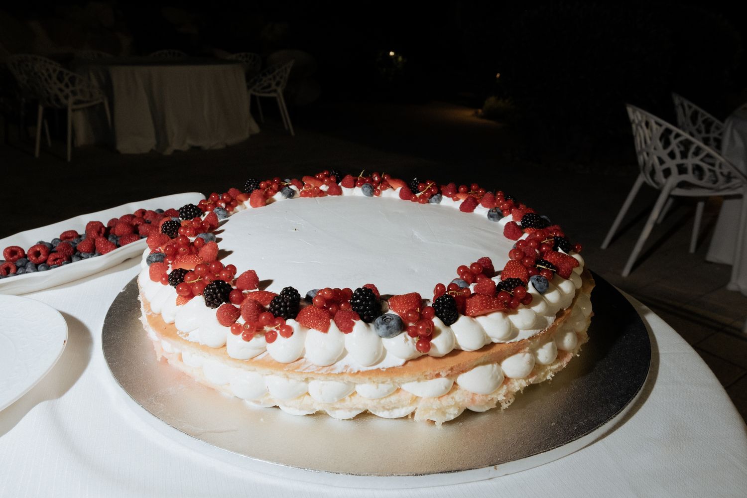 A wedding cake decorated with fresh berries and white frosting.