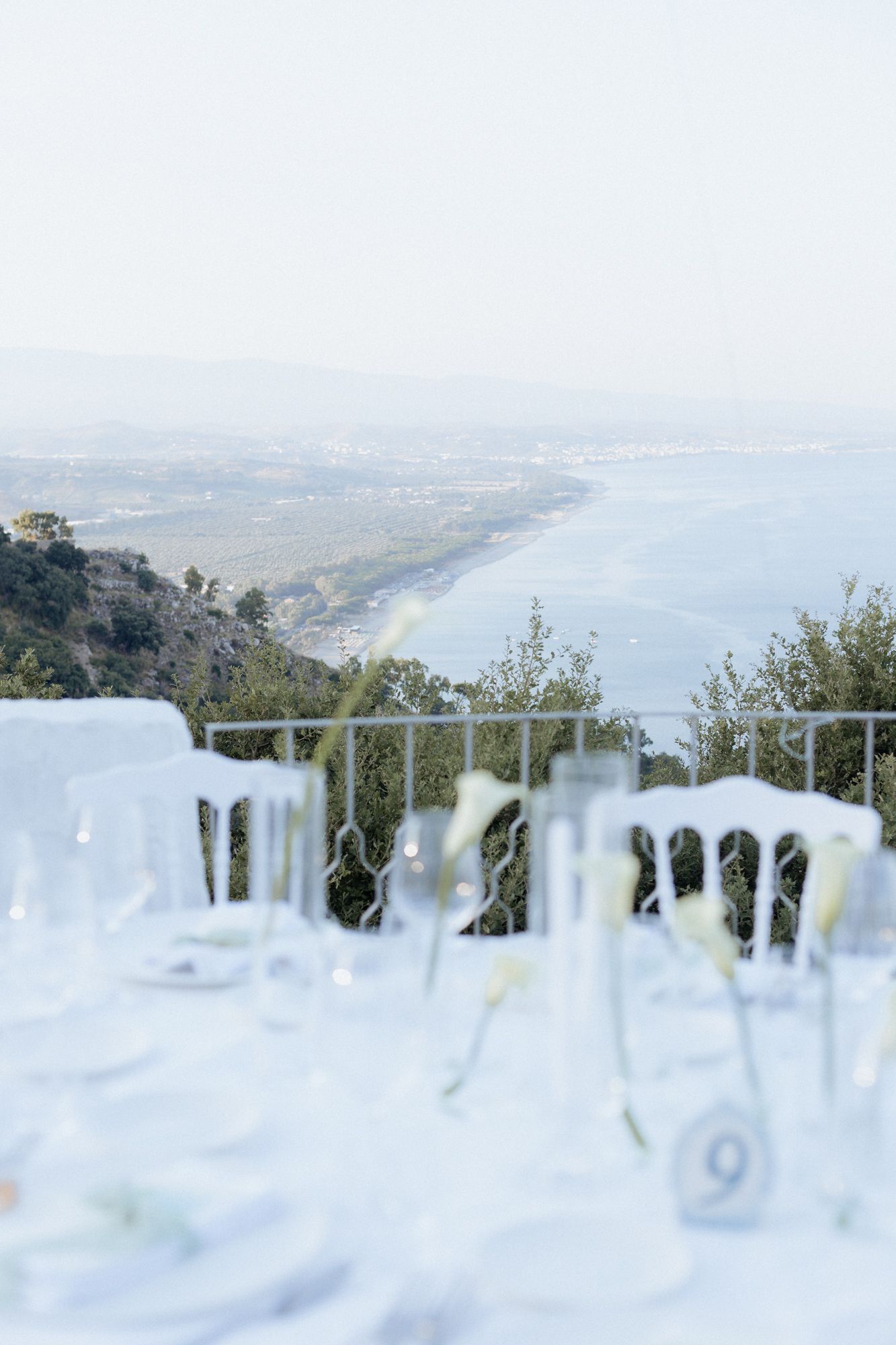 A scenic mountain overlook with glass railings offering panoramic views of the coastline below.