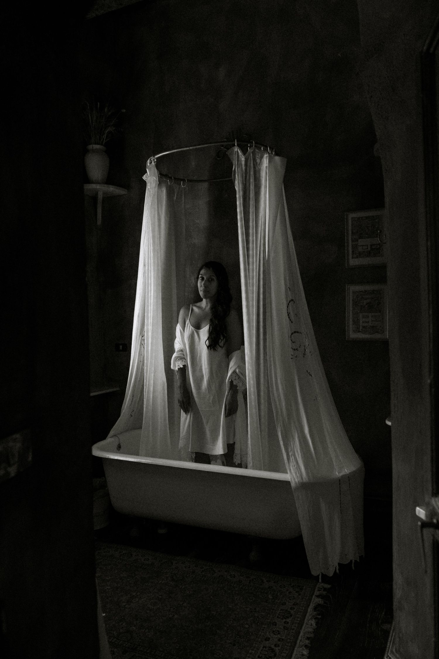 Dark moody window scene with white curtains billowing in dramatic lighting.