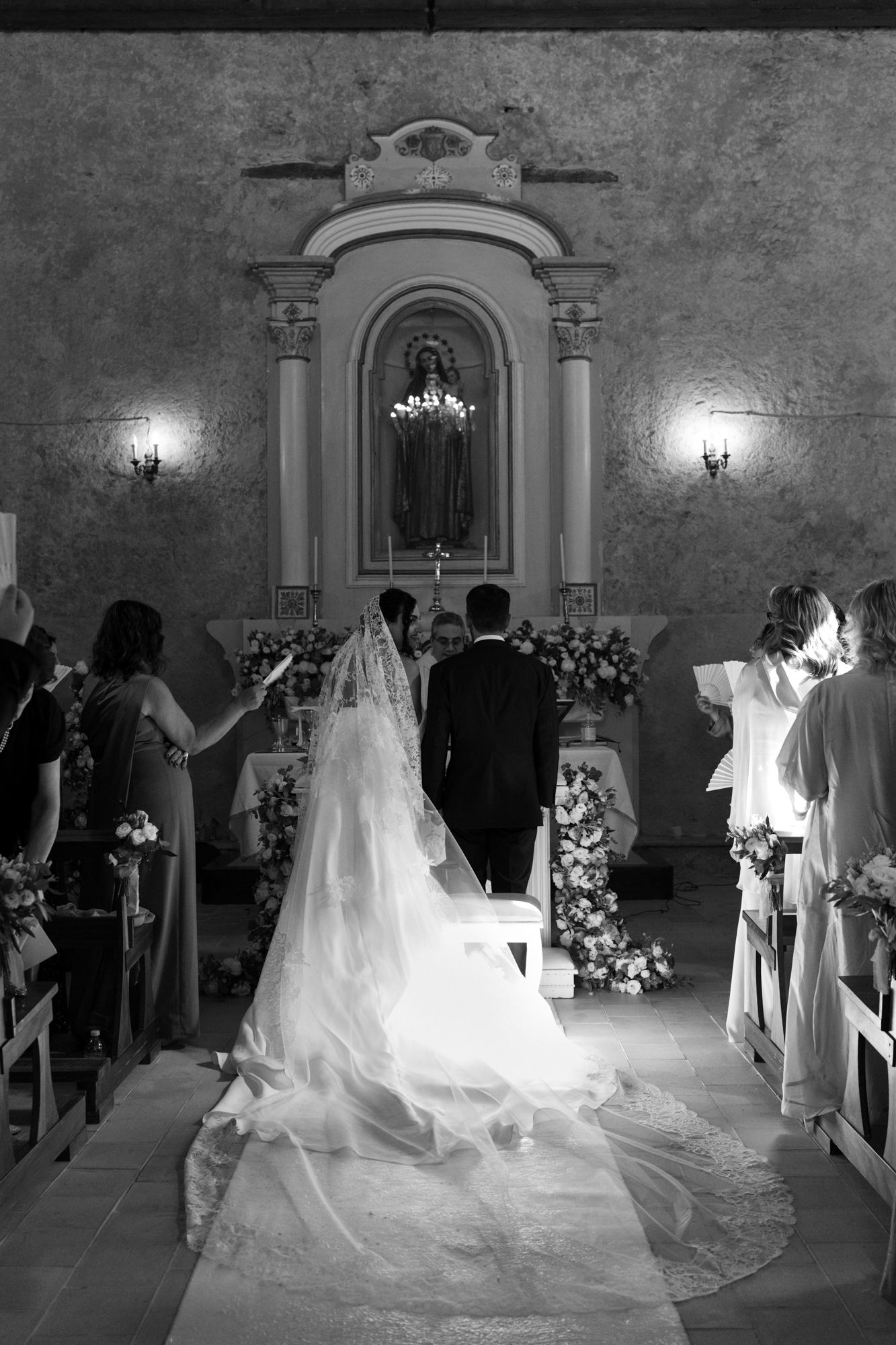A dramatic black and white photo of a wedding ceremony in a grand church with ornate architecture.