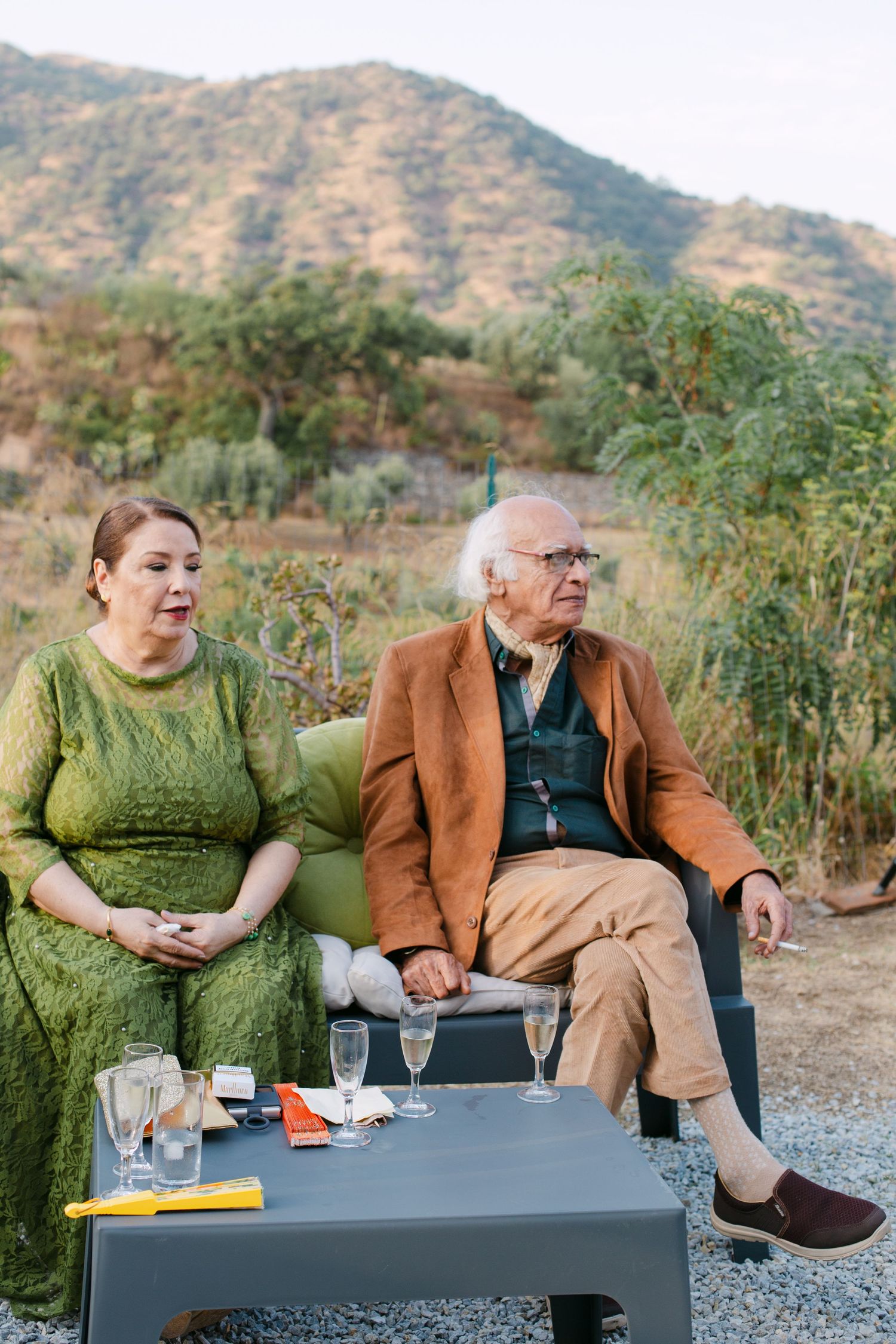 Guests relaxing on modern outdoor furniture with mountain views in the background.