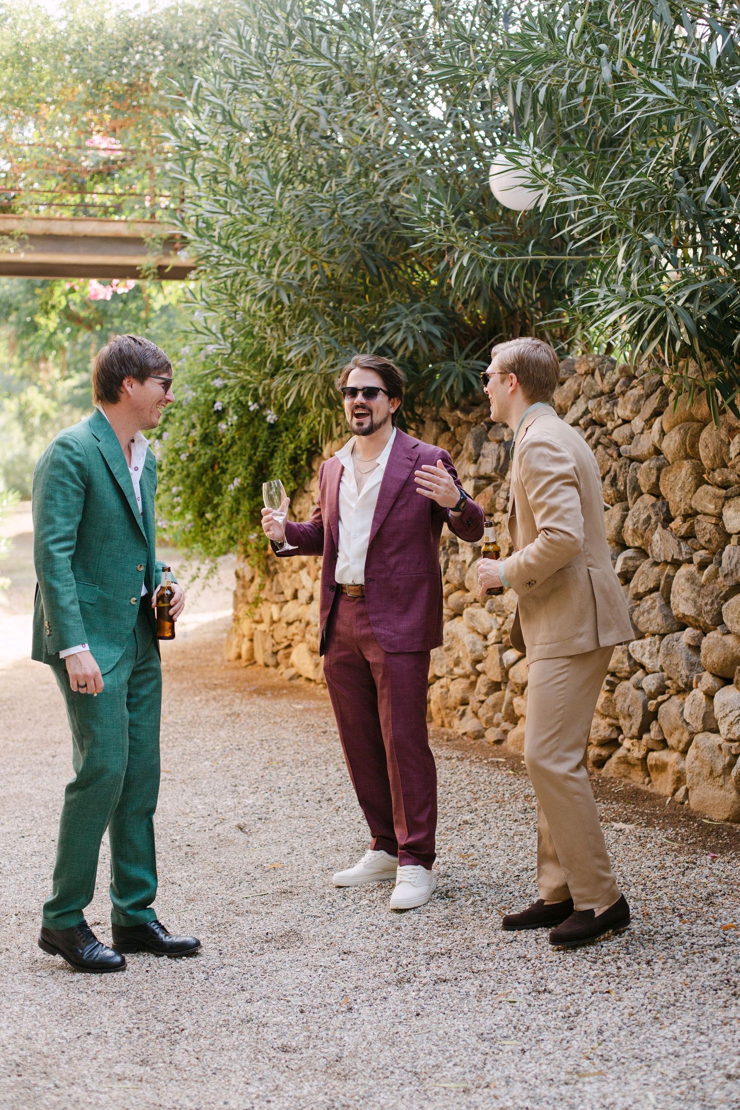 Three people in colorful suits interact playfully on a gravel path.